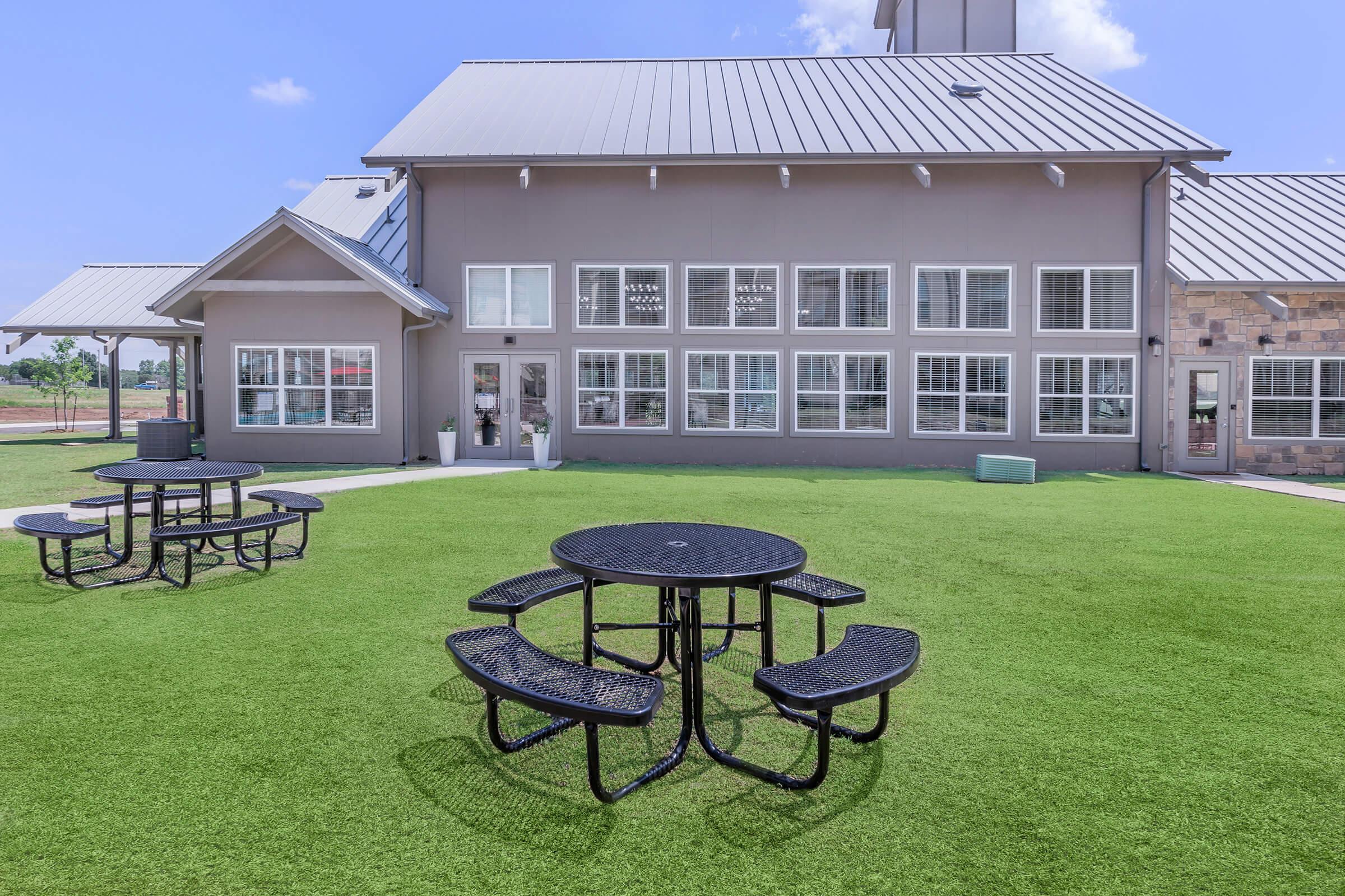 a couple of lawn chairs sitting on top of a grass covered field