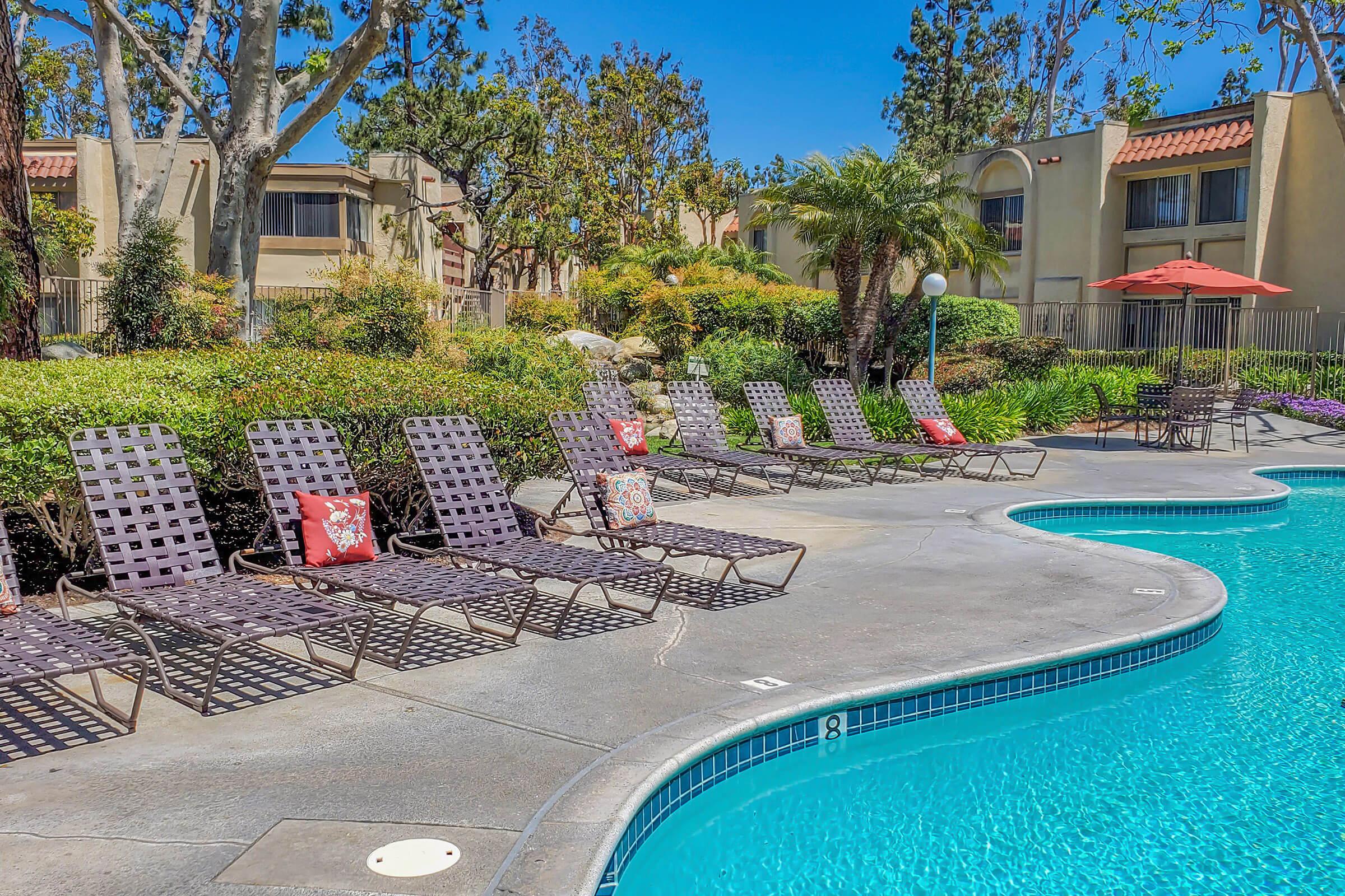 a community pool with lounge chairs