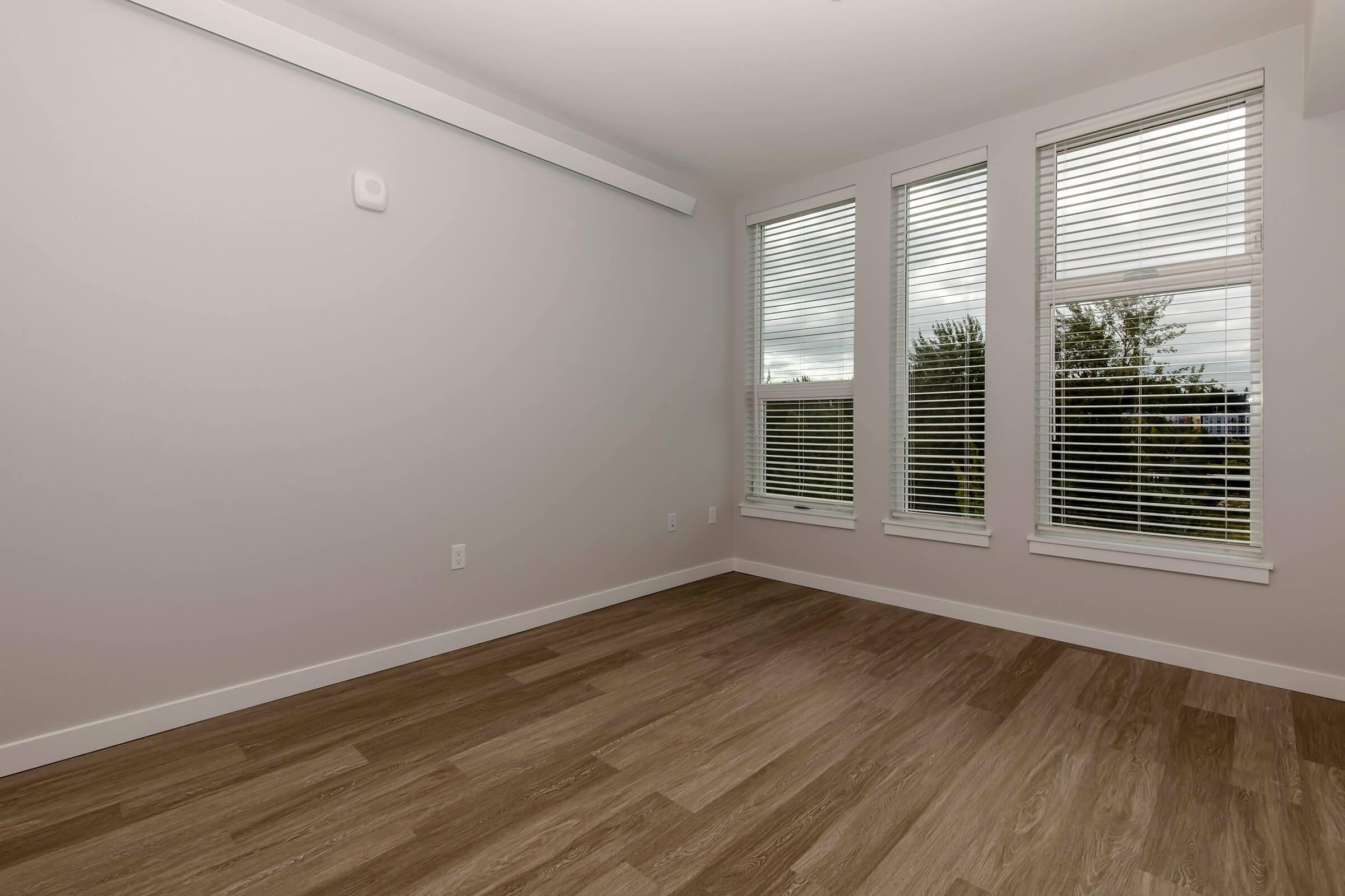 a room with wood floors and a large window