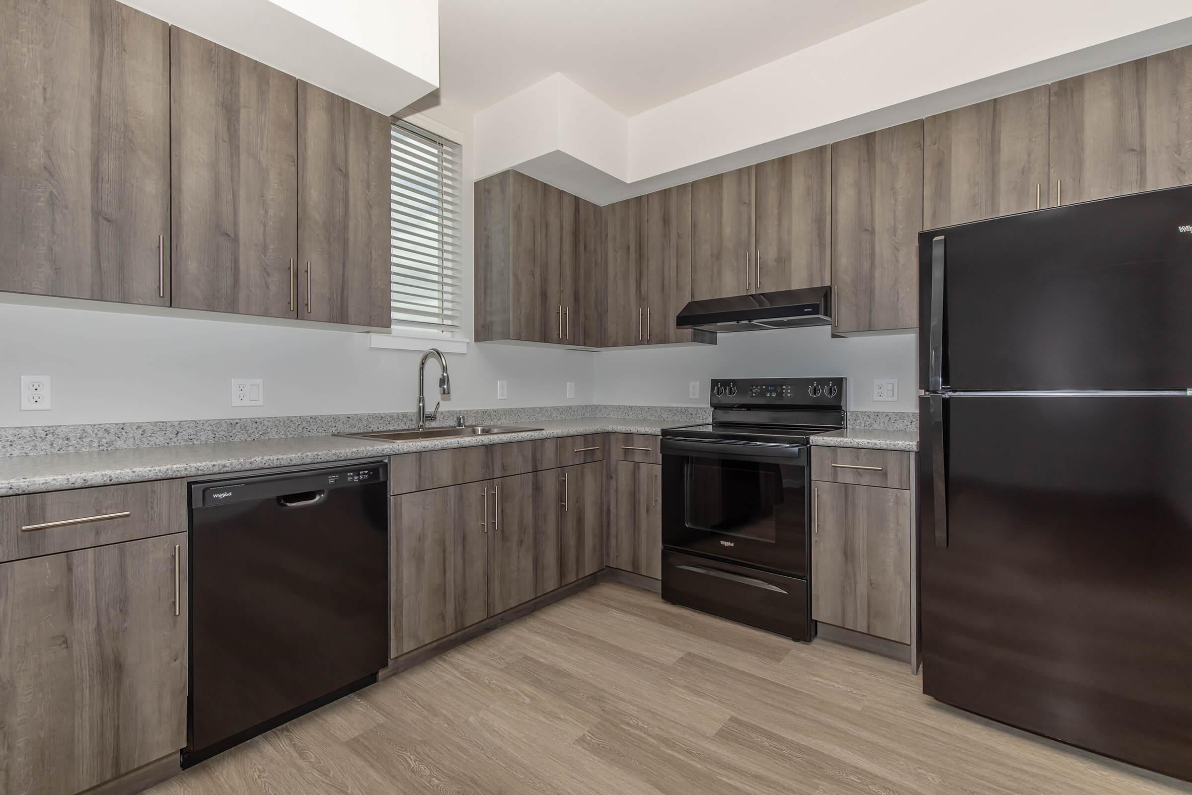 a large kitchen with stainless steel appliances and wooden cabinets