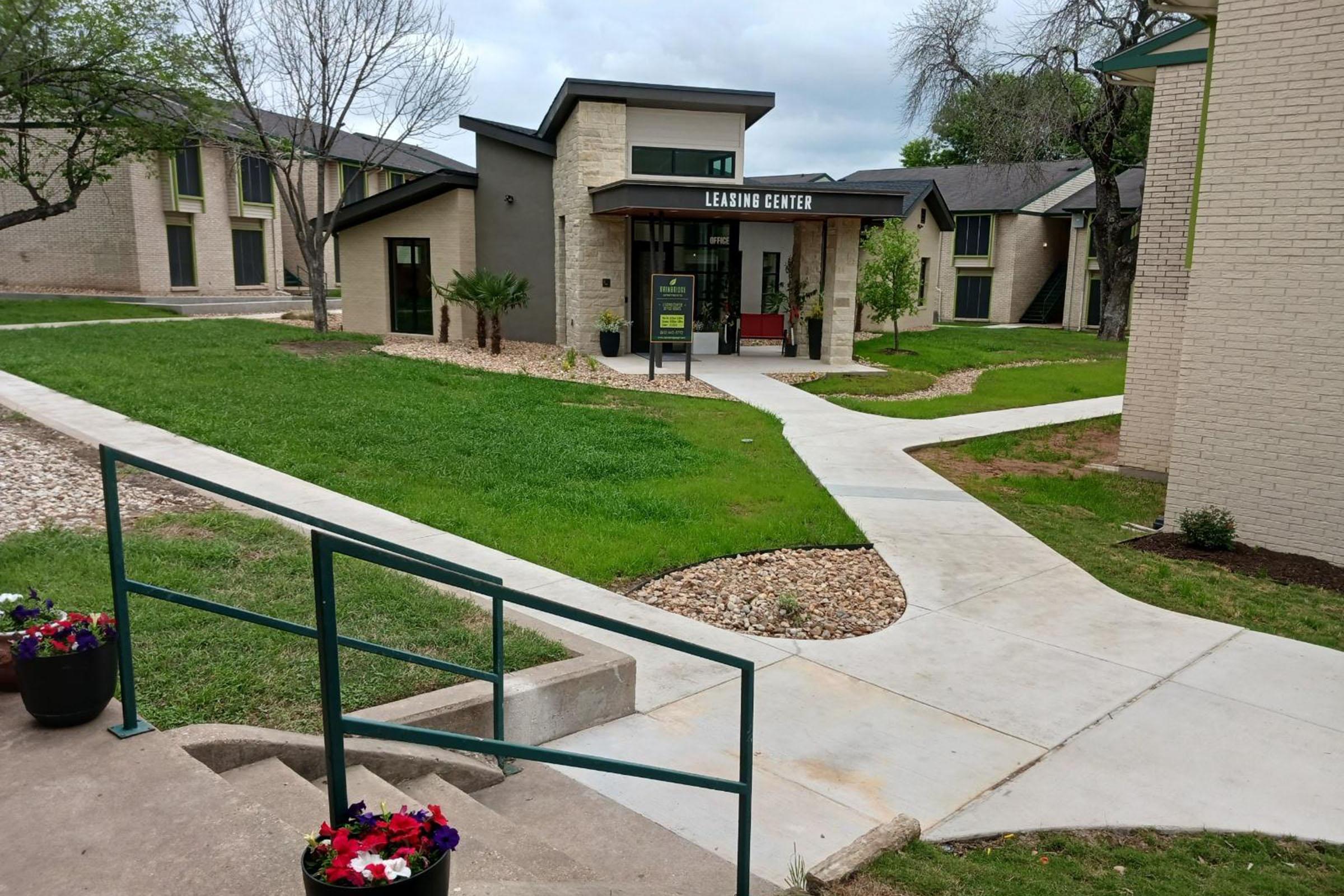 a house with a lawn in front of a brick building