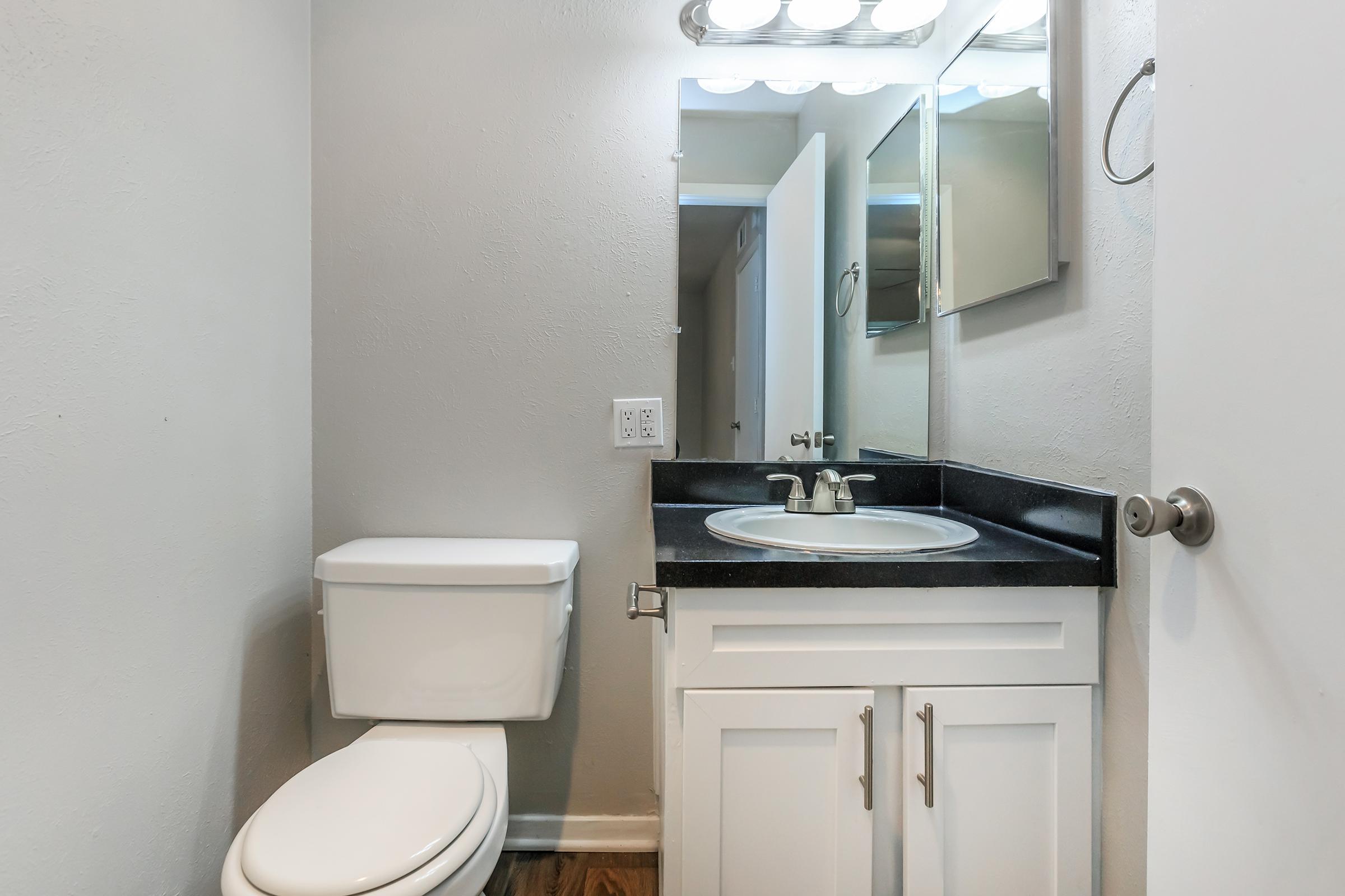 a white sink sitting under a mirror