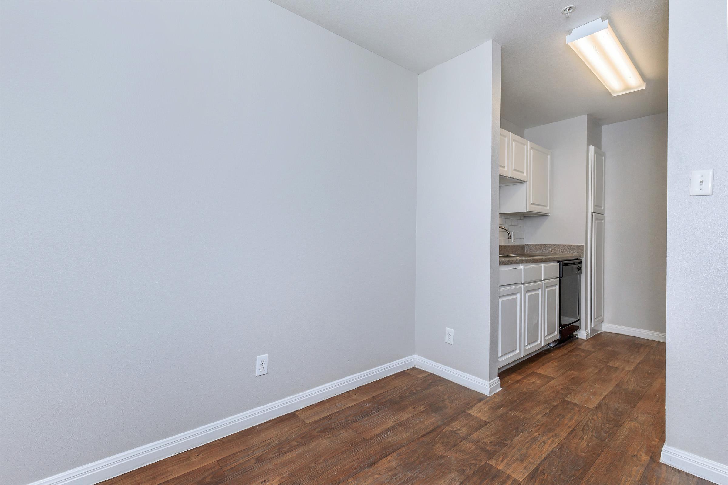 a large empty room with a sink and a mirror