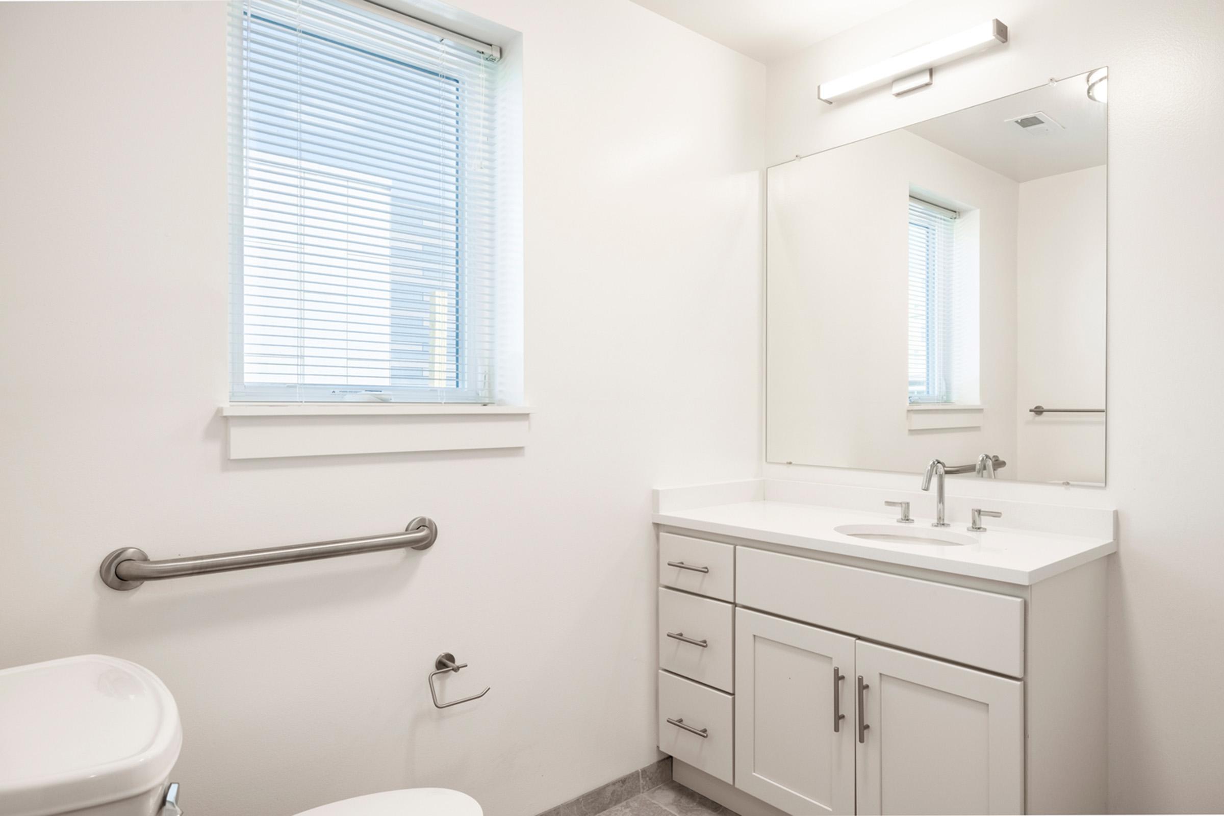 a room with a sink mirror and window