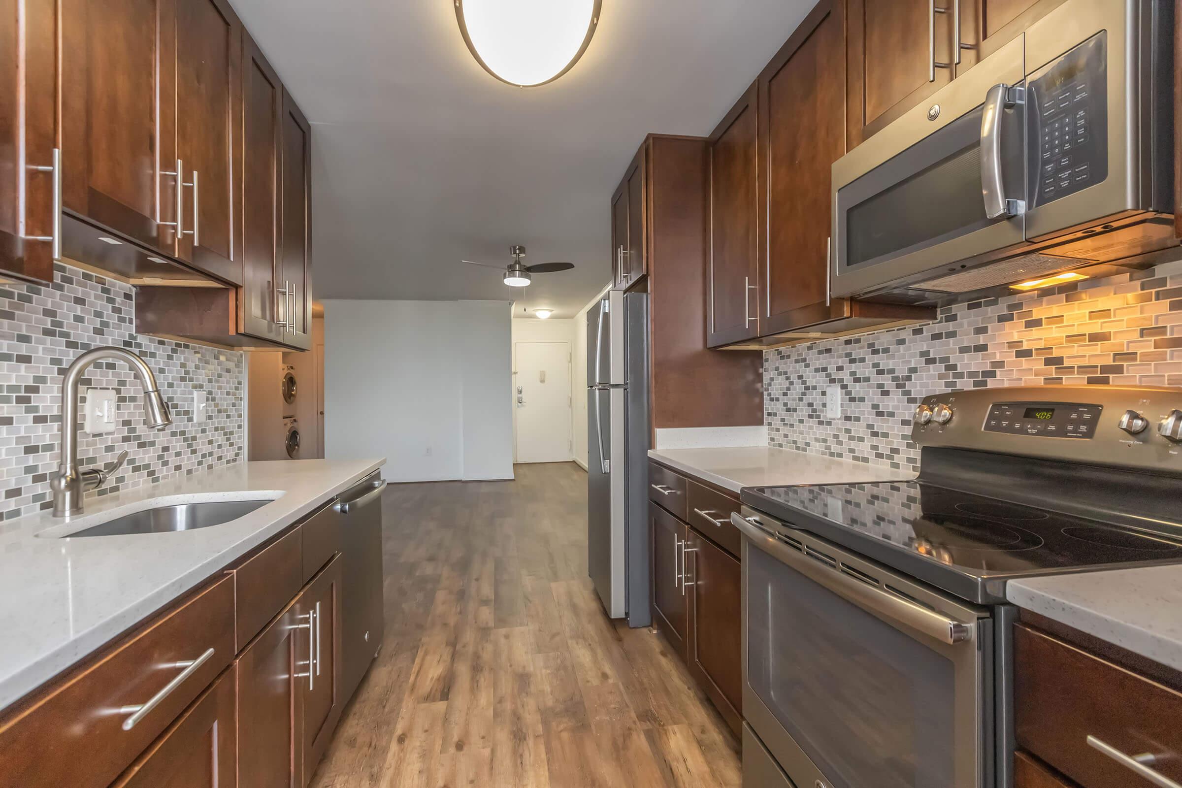 a large kitchen with stainless steel appliances and wooden cabinets