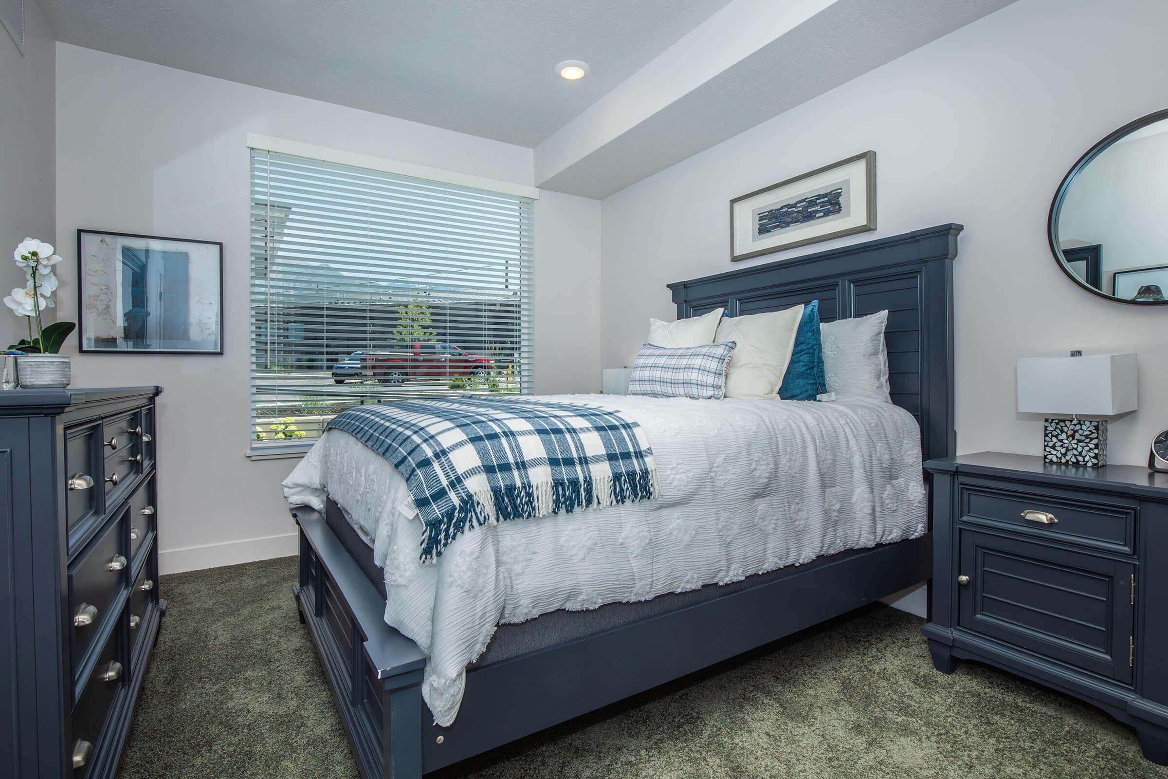 a bedroom with a bed and desk in a room