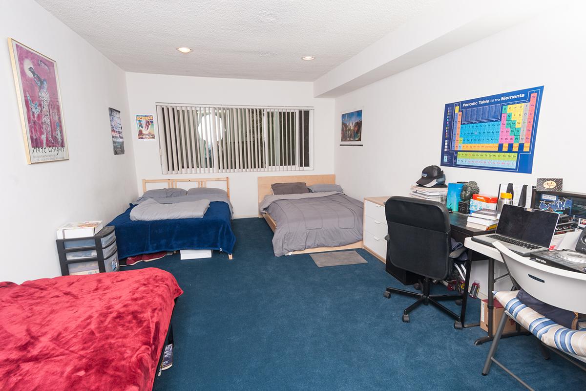 a bedroom with a bed and desk in a room