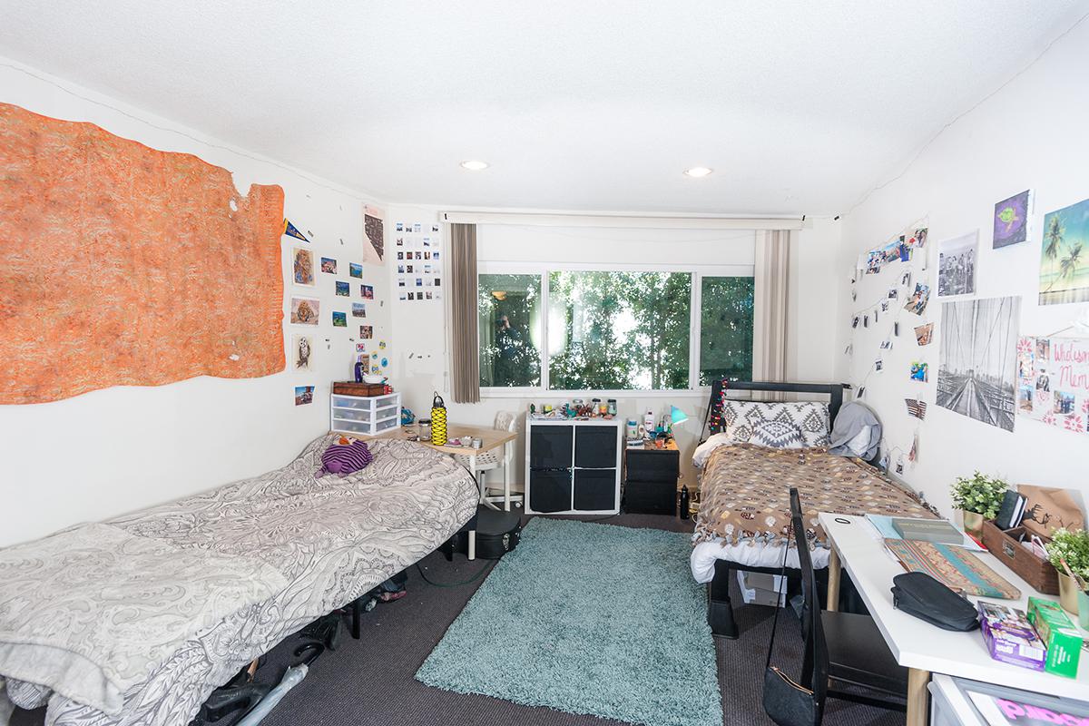 a bedroom with a bed and desk in a room