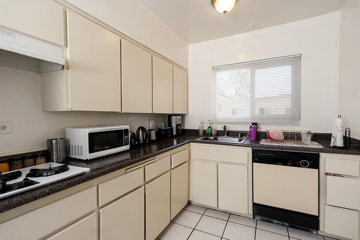 a kitchen with white cabinets and black counter