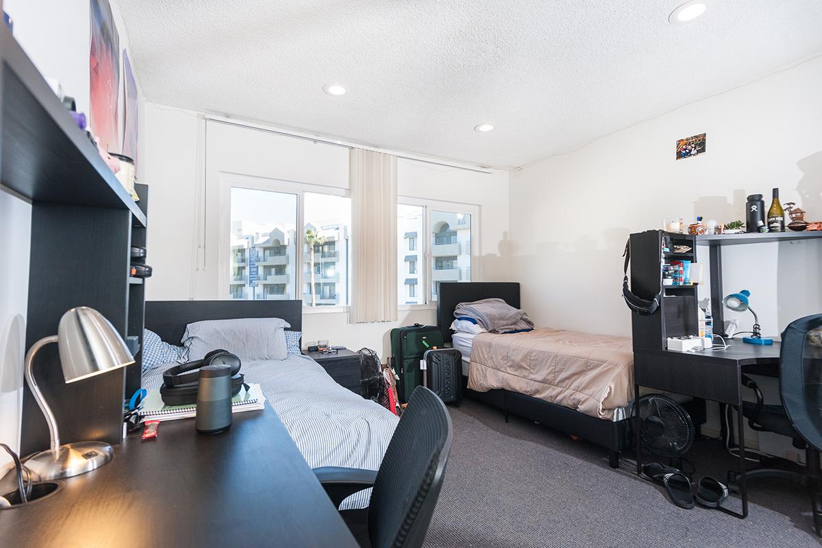 a bedroom with a bed and desk in a room