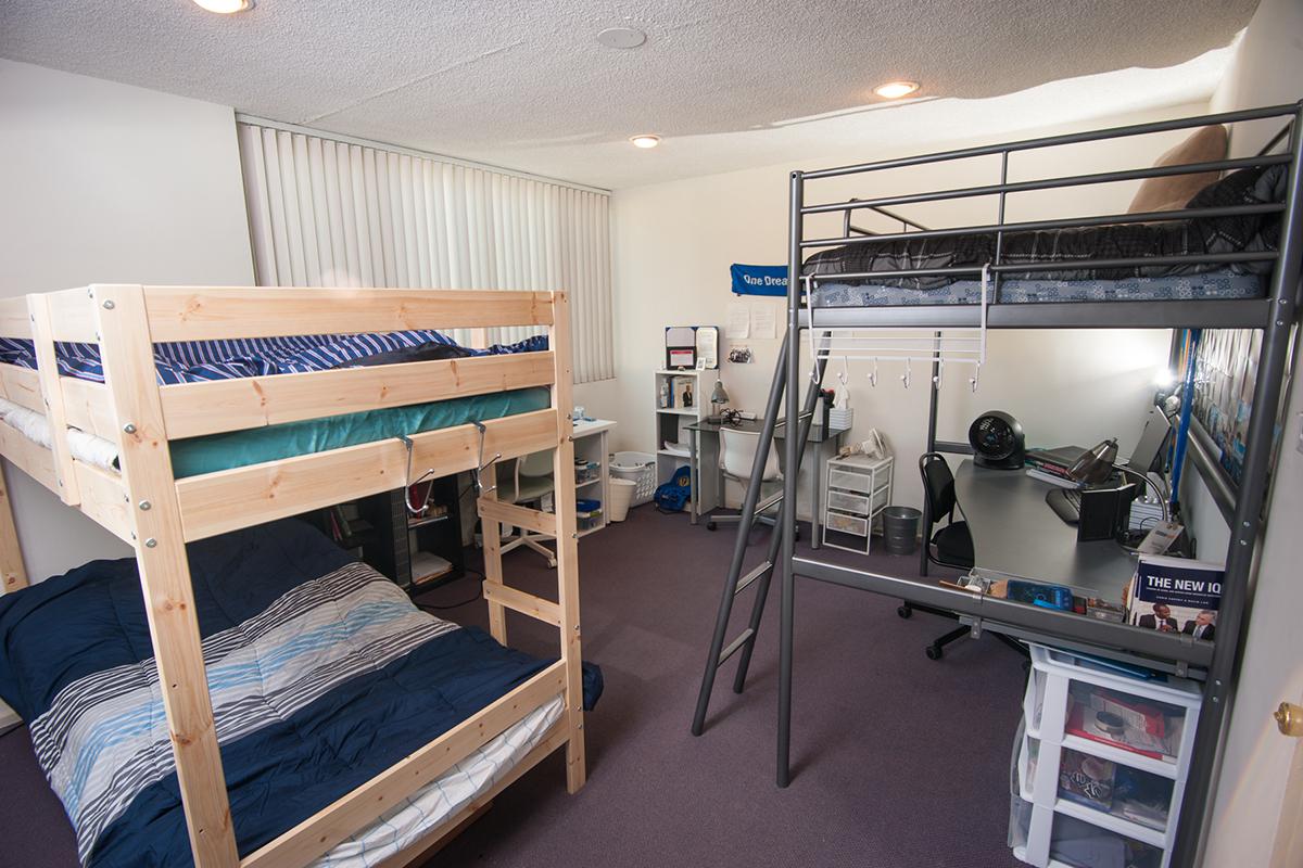 a bedroom with a bed and desk in a room