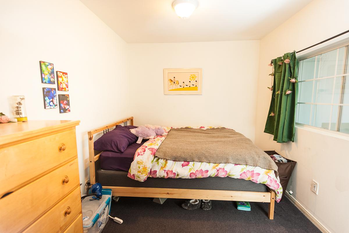 a bedroom with a bed and desk in a small room