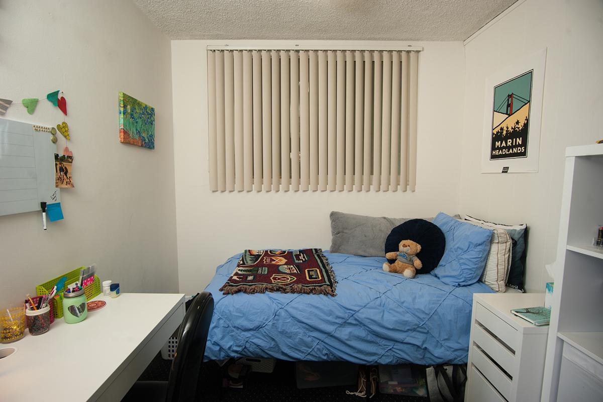 a bedroom with a bed and desk in a room