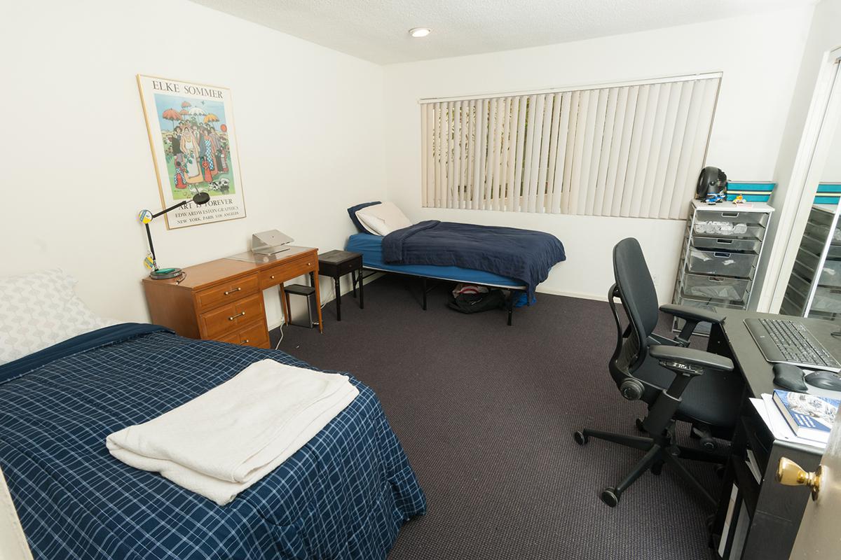 a bedroom with a desk and chair in a room