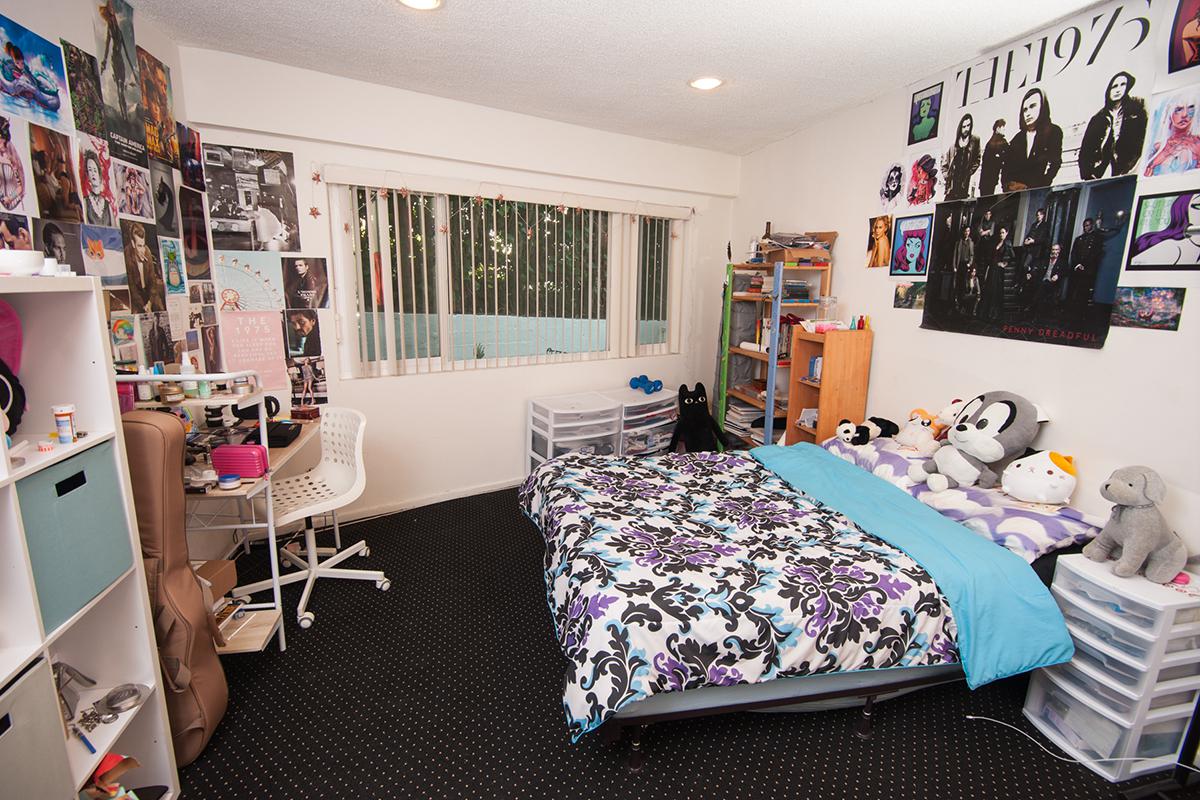 a bedroom with a bed and desk in a room