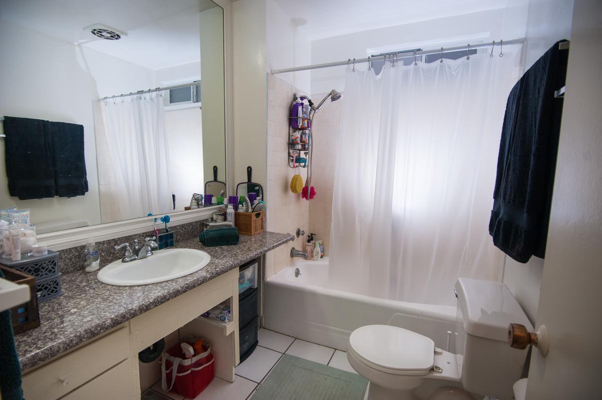 a white sink sitting under a mirror