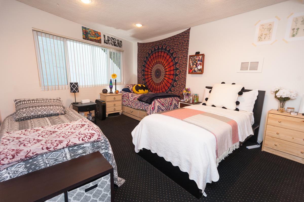 a bedroom with a bed and desk in a hotel room