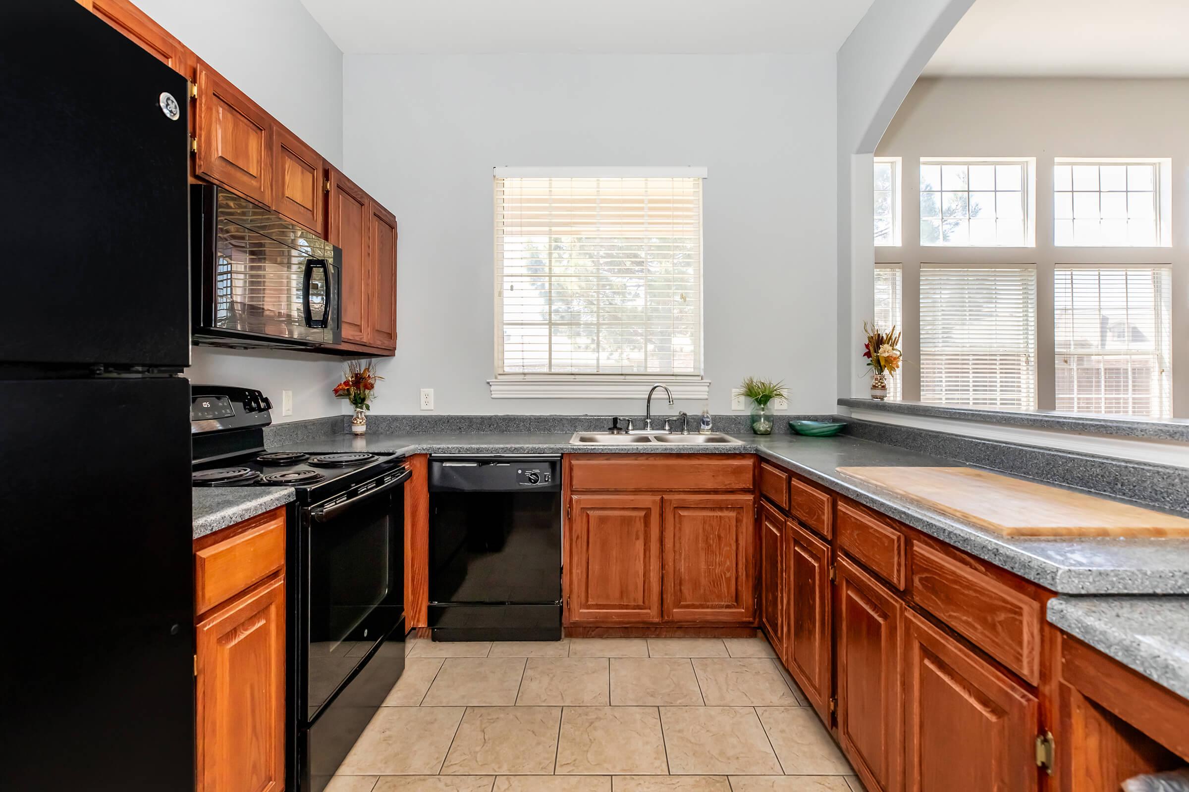 a large kitchen with stainless steel appliances and wooden cabinets