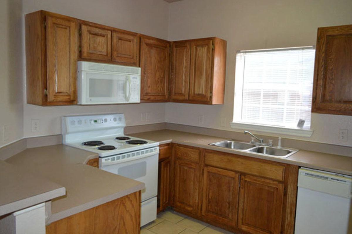 a kitchen with wooden cabinets and a microwave