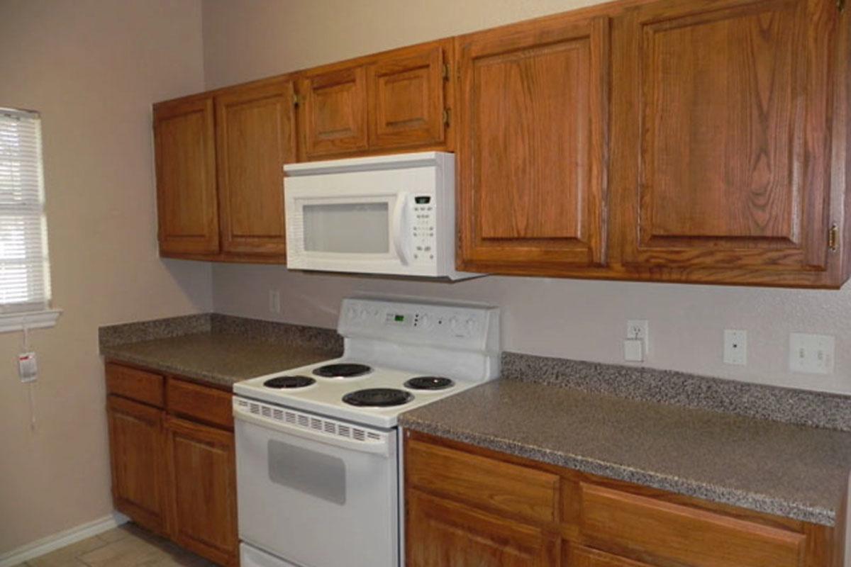 a kitchen with wooden cabinets and a microwave