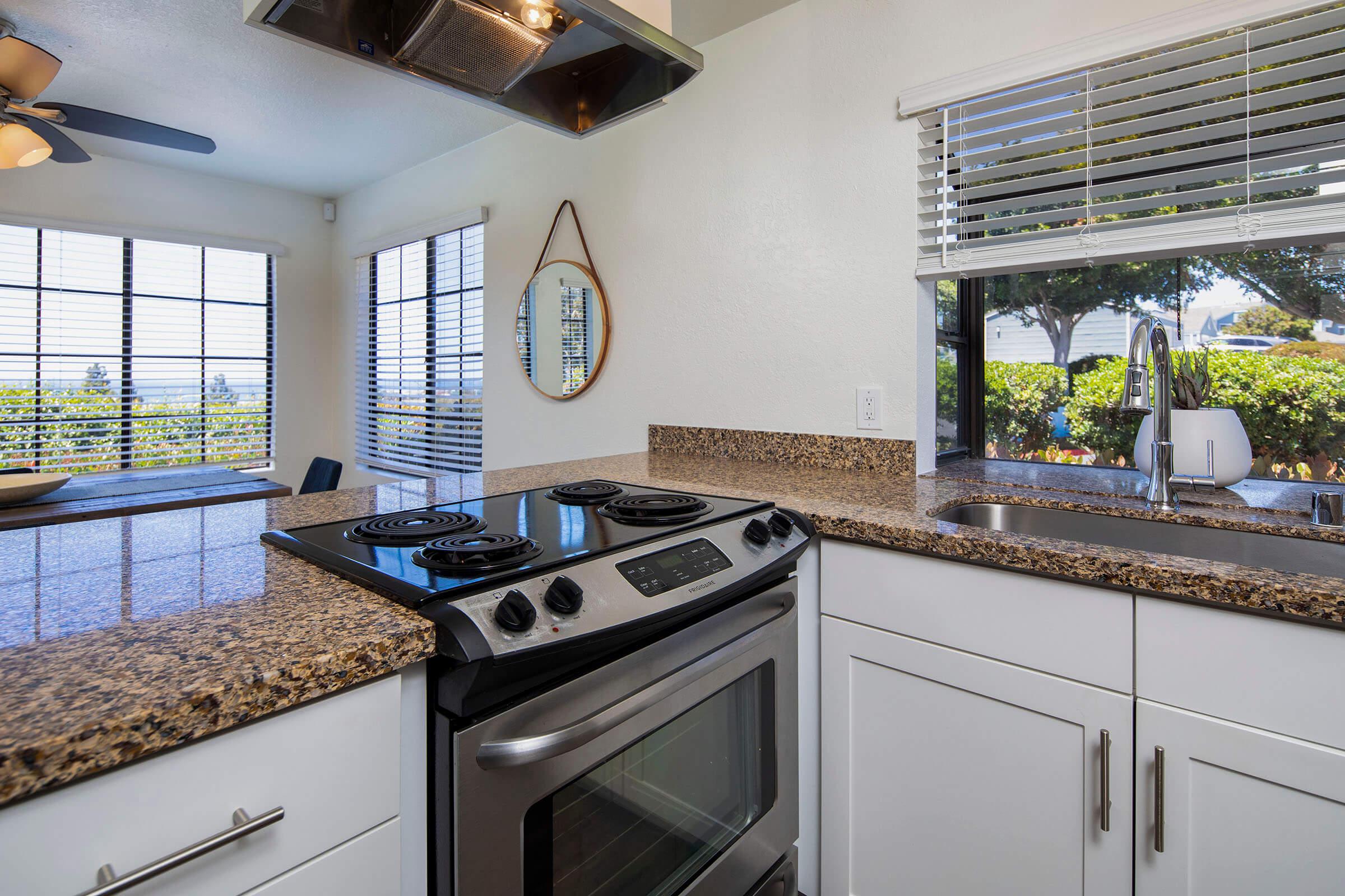 a kitchen with a stove a sink and a window