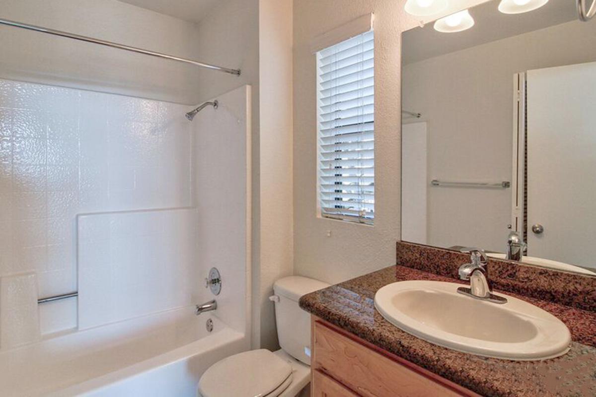 a white sink sitting under a mirror