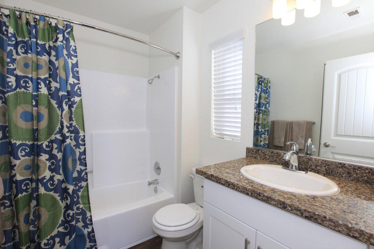 a white sink and shower curtain