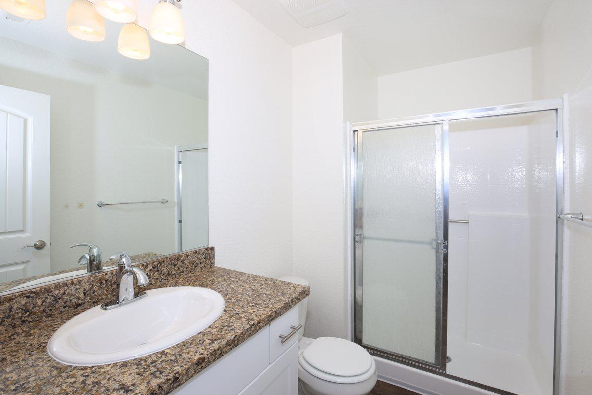 a glass shower door next to a sink