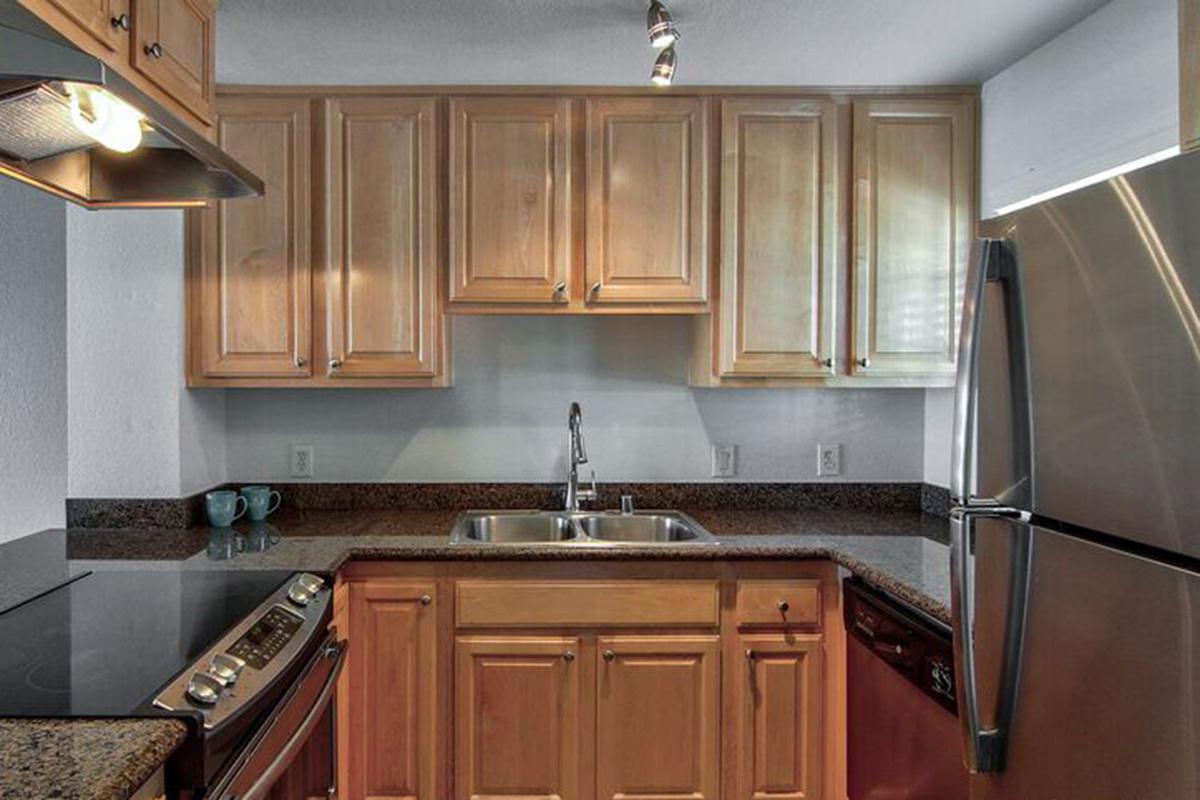 a kitchen with stainless steel appliances and wooden cabinets