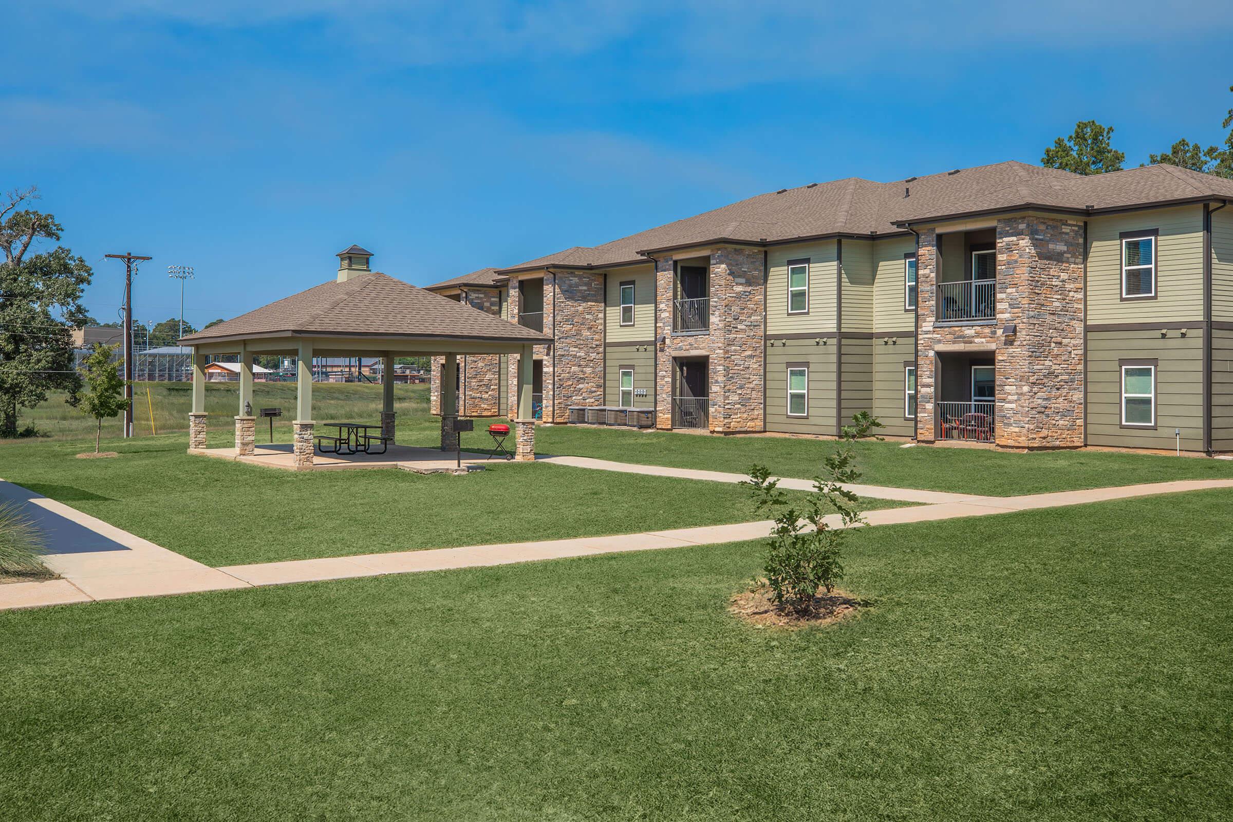 a house with a lawn in front of a brick building