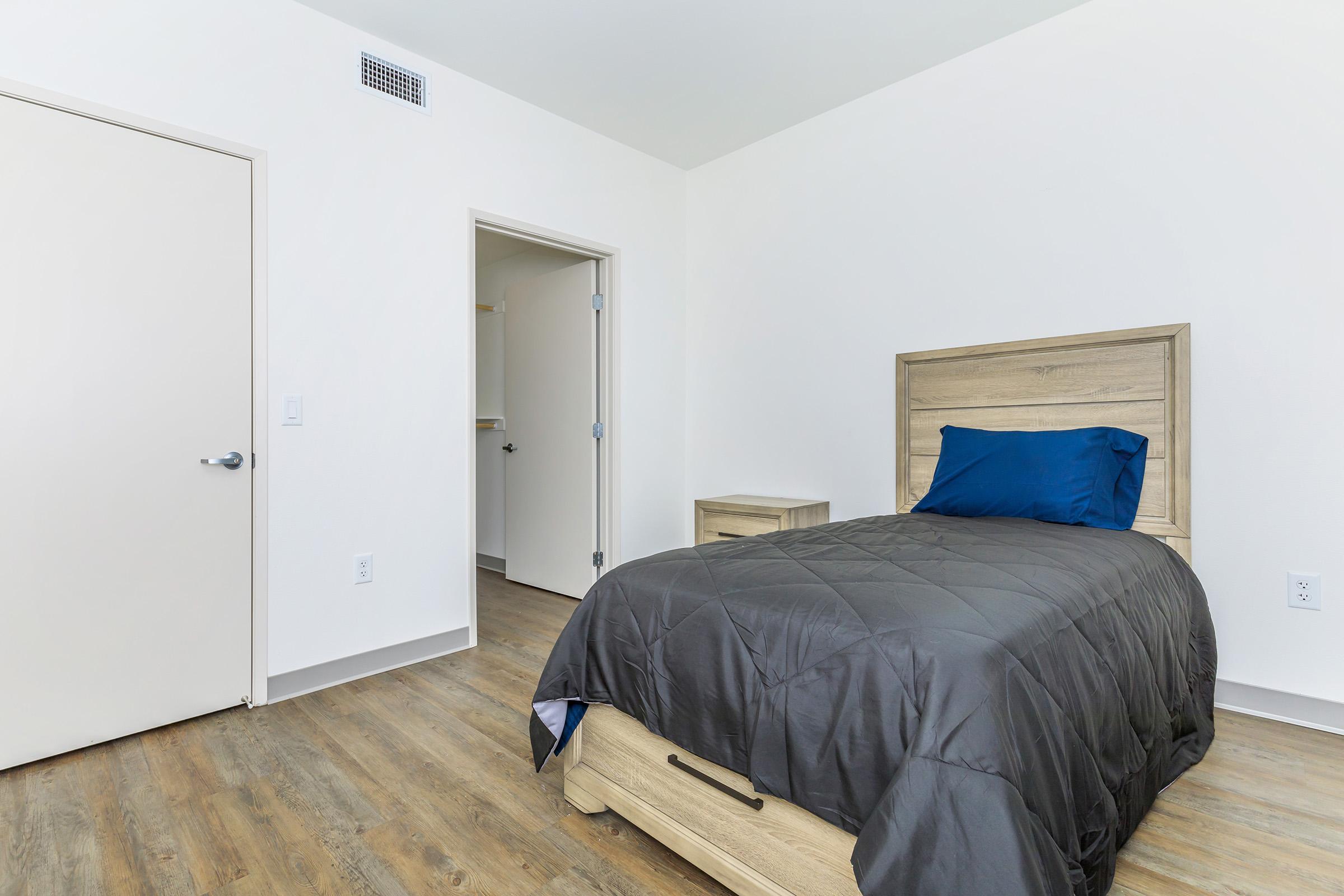 a bedroom with a bed and desk in a room