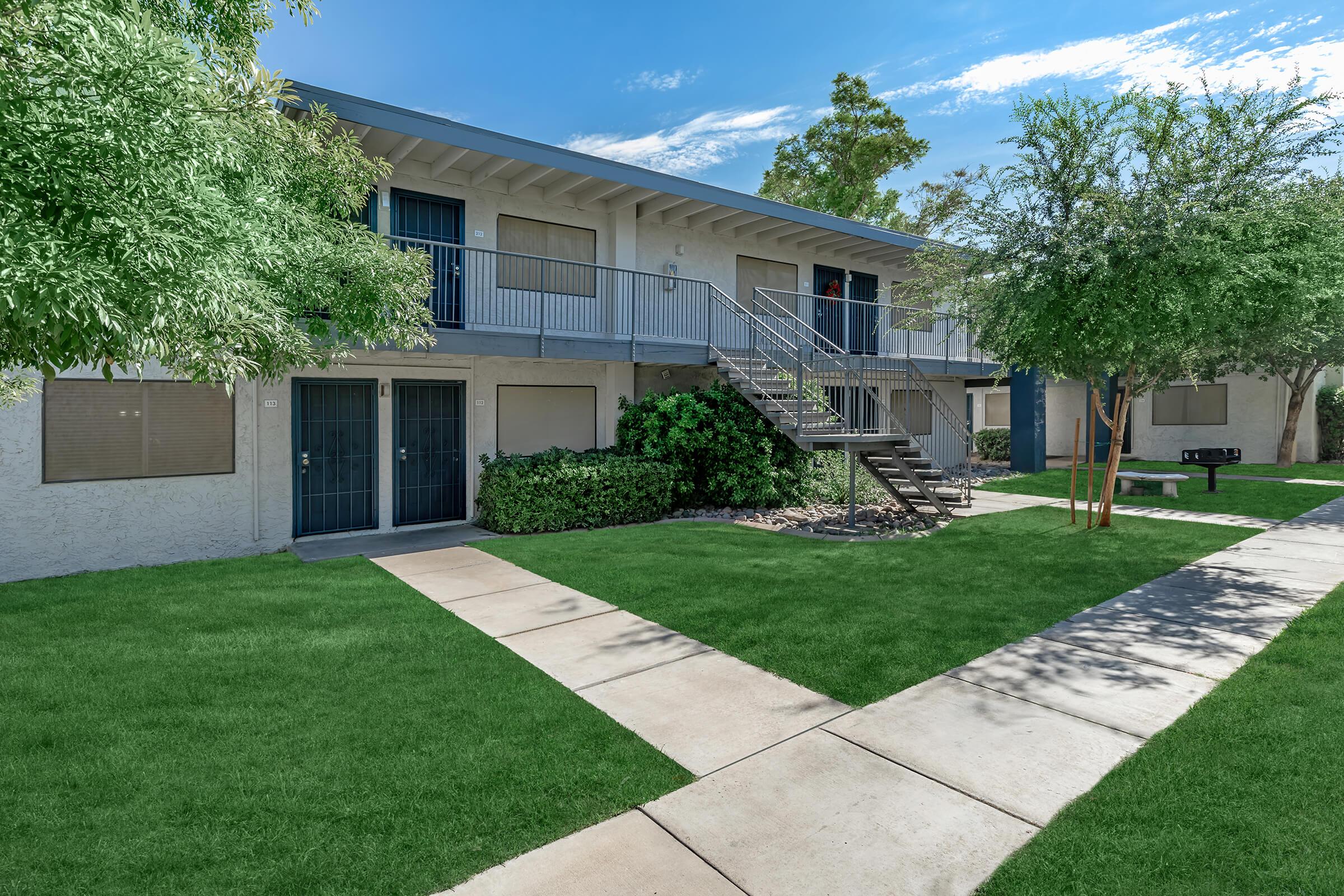 Outdoor courtyard grass area beside large 2 story apartment buildings