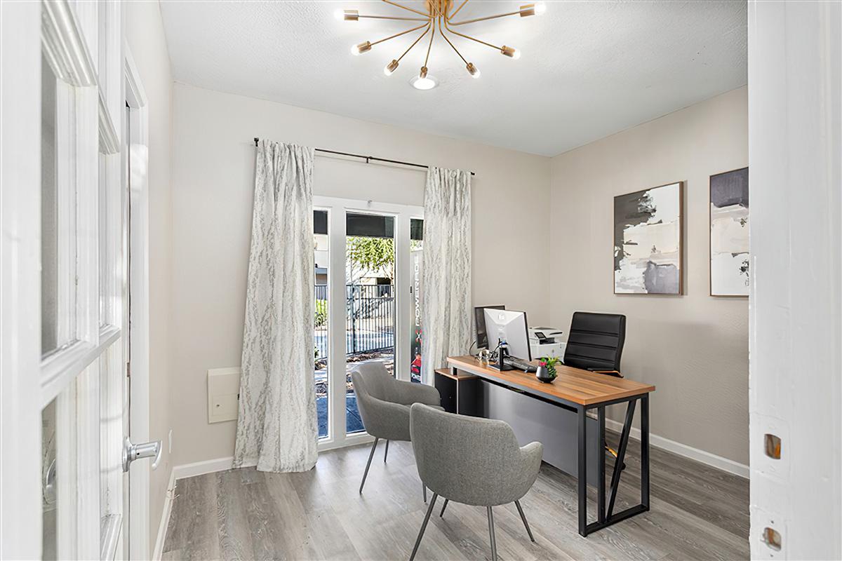 An office in an apartment with sliding doors to a patio at Rise at the Preserve. 