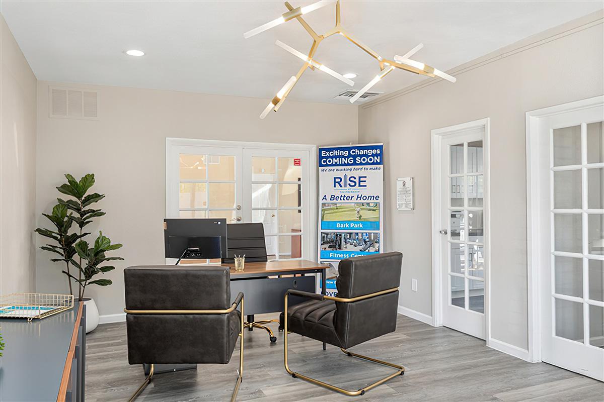 The leasing office at Rise at the Preserve with a desk and chairs. 