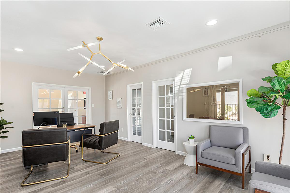 The leasing office at Rise at the Preserve with a desk and chairs. 