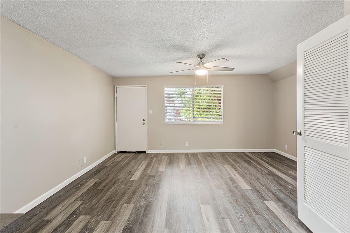 The living room with wood-style floors and a large window at Rise at the Preserve.