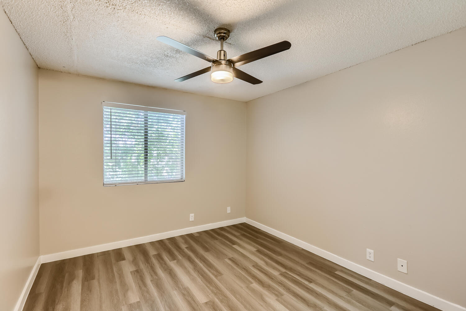 A bedroom with wood-style floors, a ceiling fan, and. window at Rise at the Preserve. 