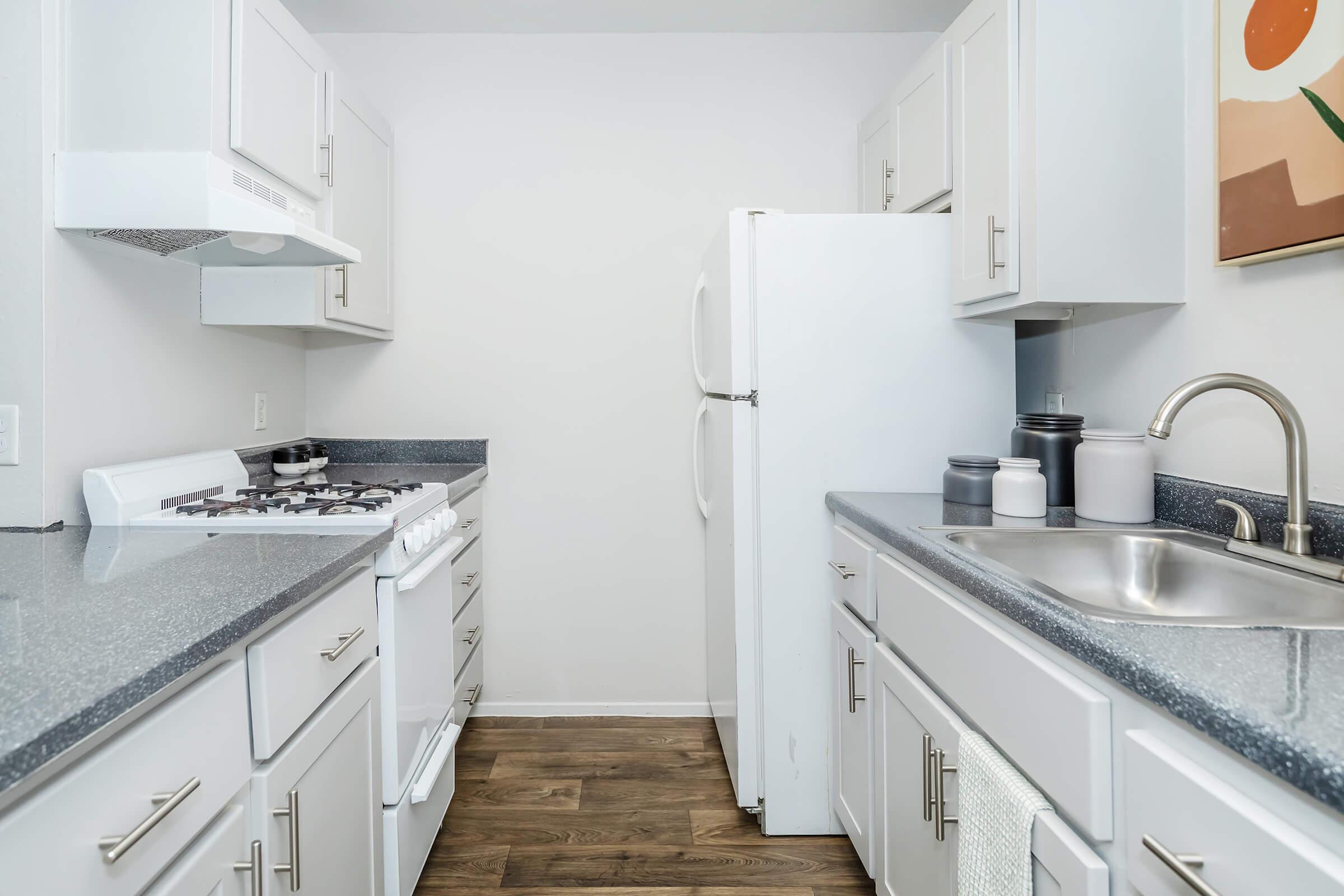 A kitchen at Rise at the Preserve with white appliances and cabinets.