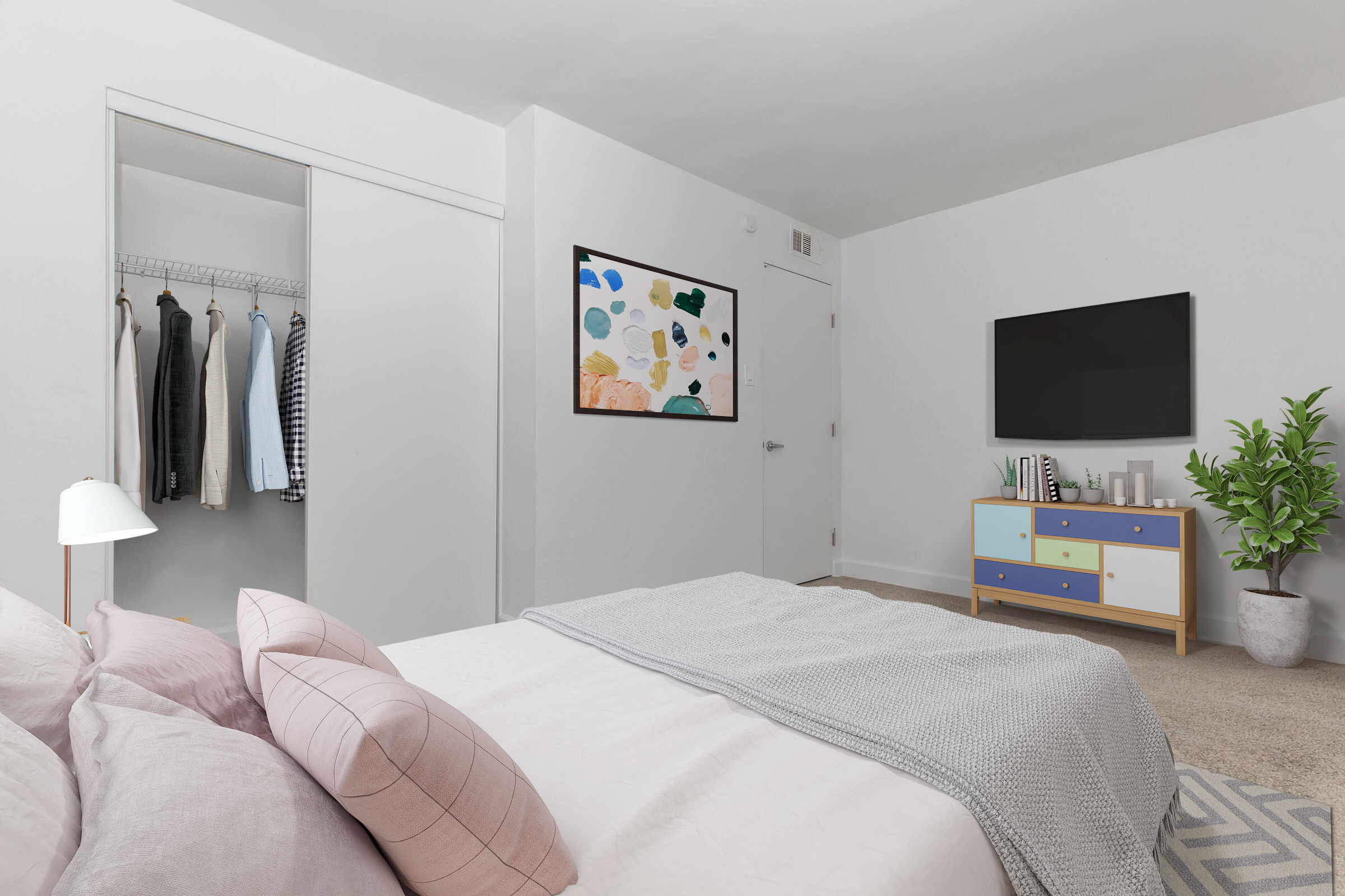 A modern bedroom featuring a neatly made bed with decorative pillows, a wall-mounted TV, a colorful dresser, and a closet with hanging clothes. The room has light-colored walls, a piece of abstract art on the wall, and a potted plant, creating a cozy and inviting atmosphere.