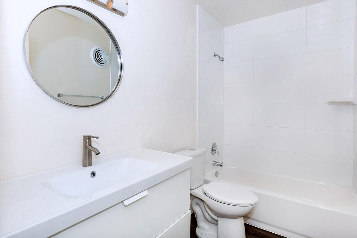 a white sink sitting next to a shower