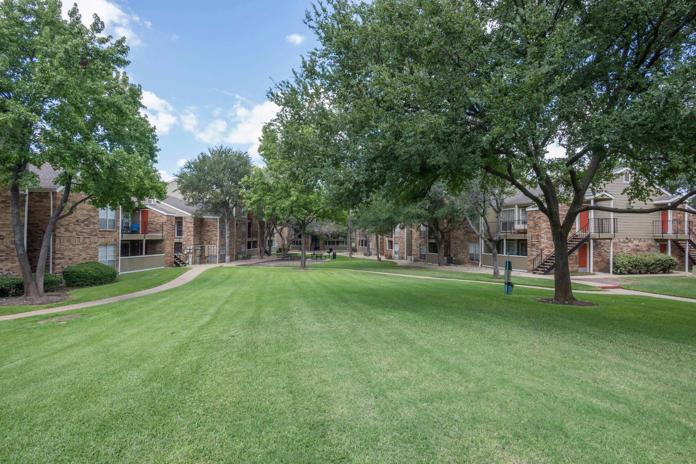 a green field between community buildings