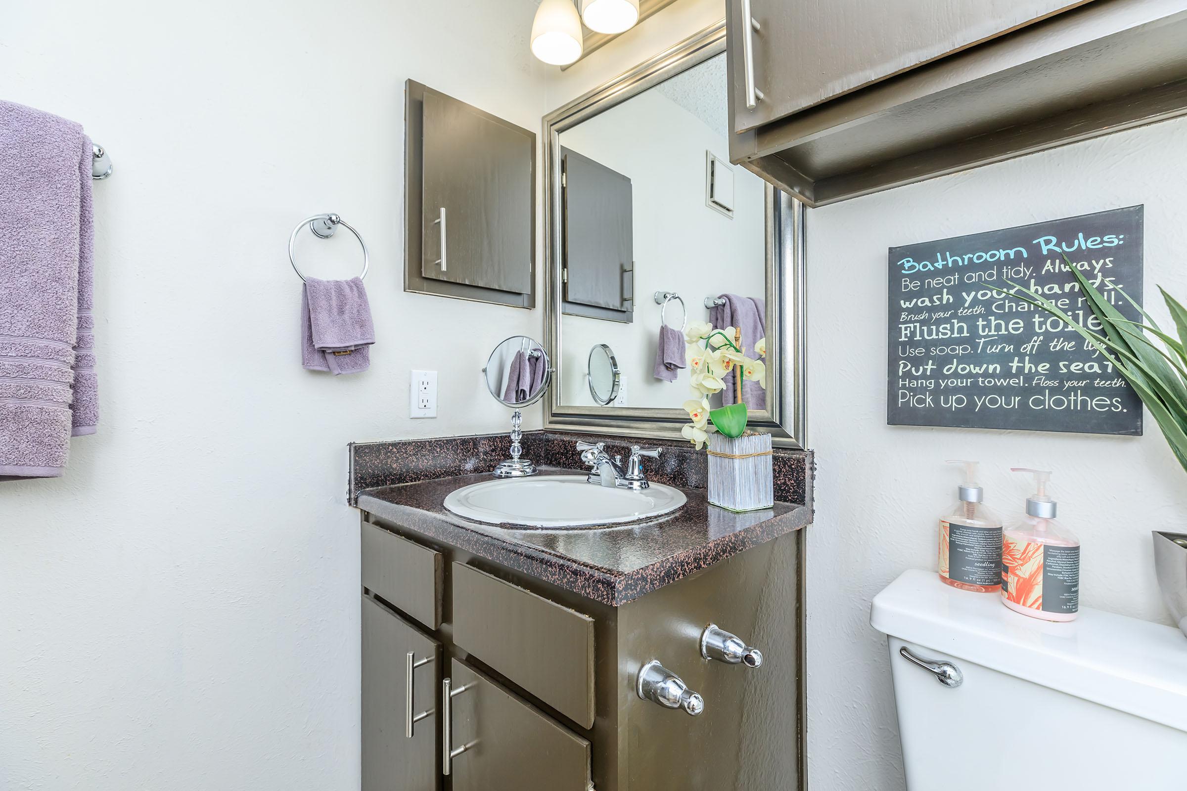 furnished bathroom with wooden cabinets