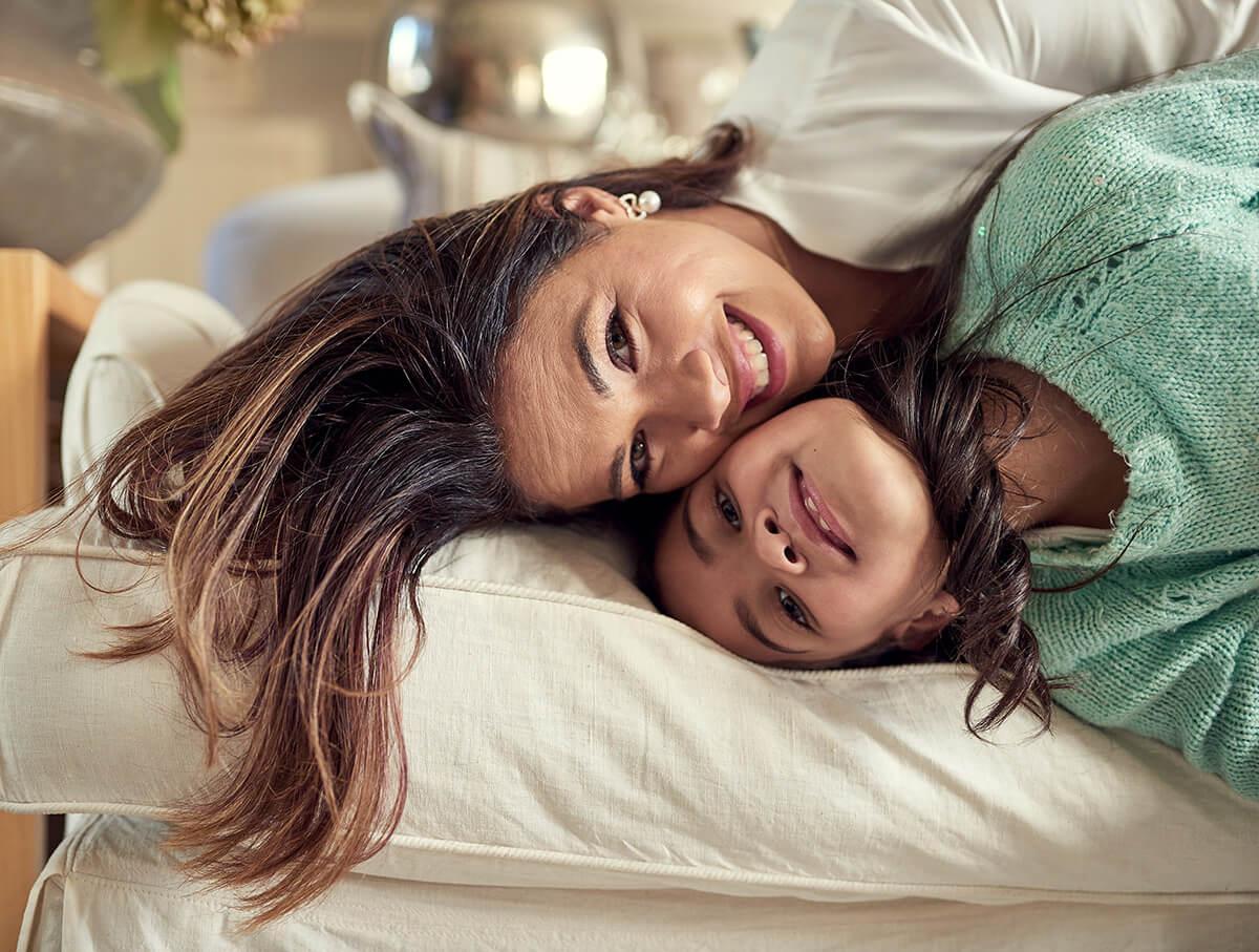 a woman and child lying on a bed