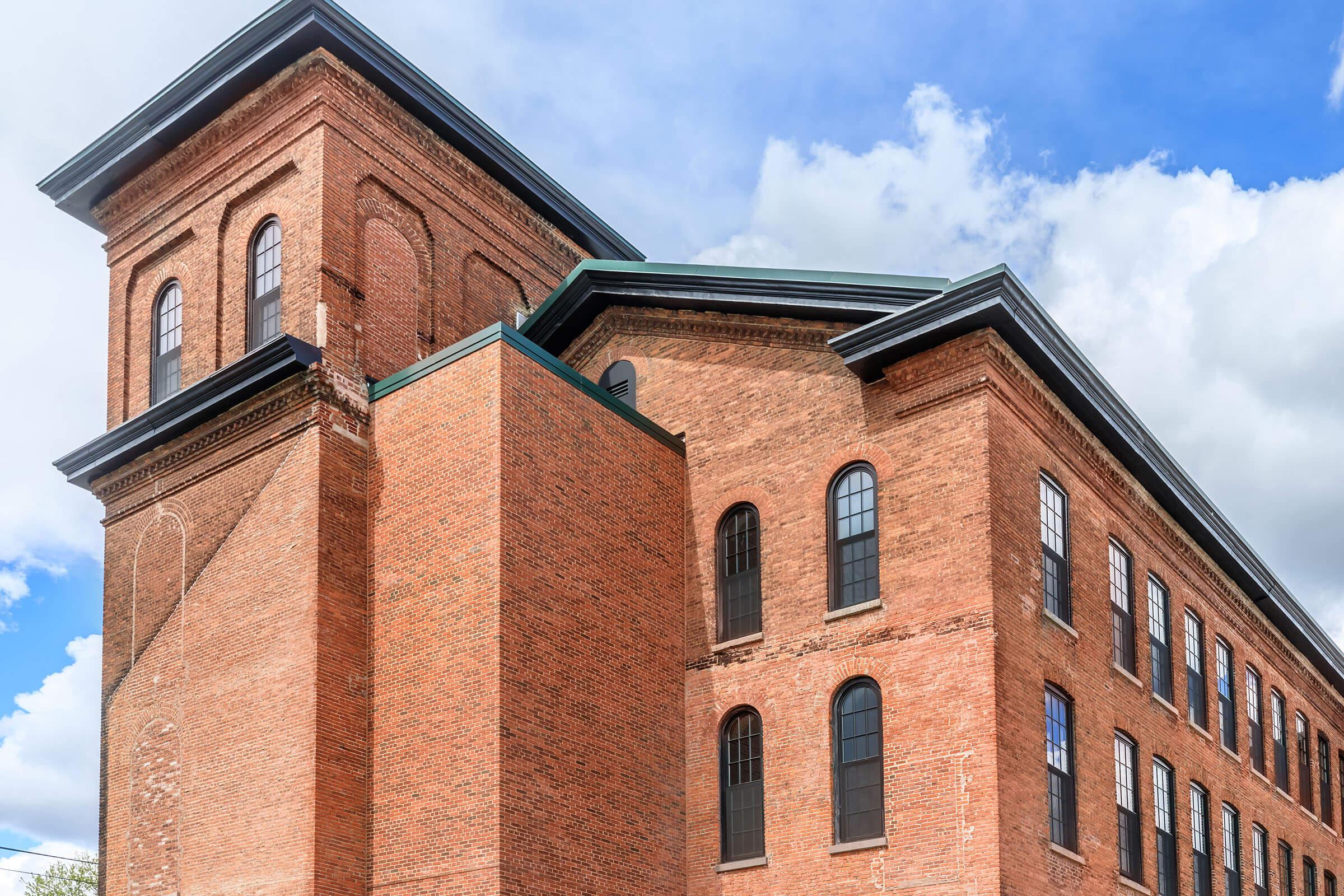 a large brick tower with a clock on the side of a building