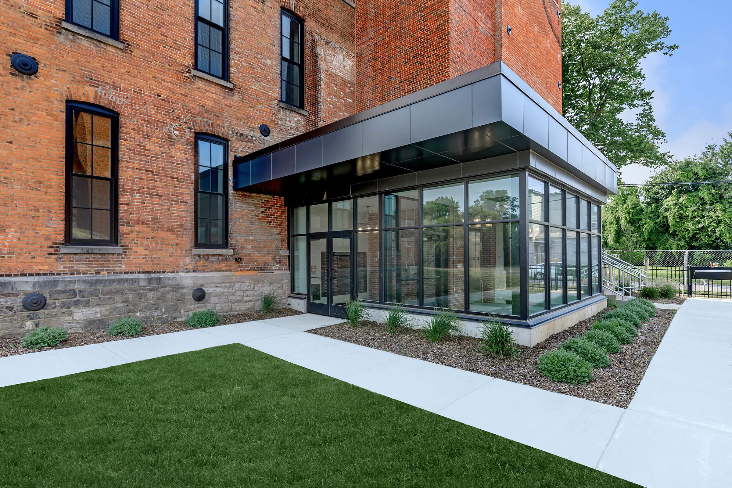 a large lawn in front of a brick building