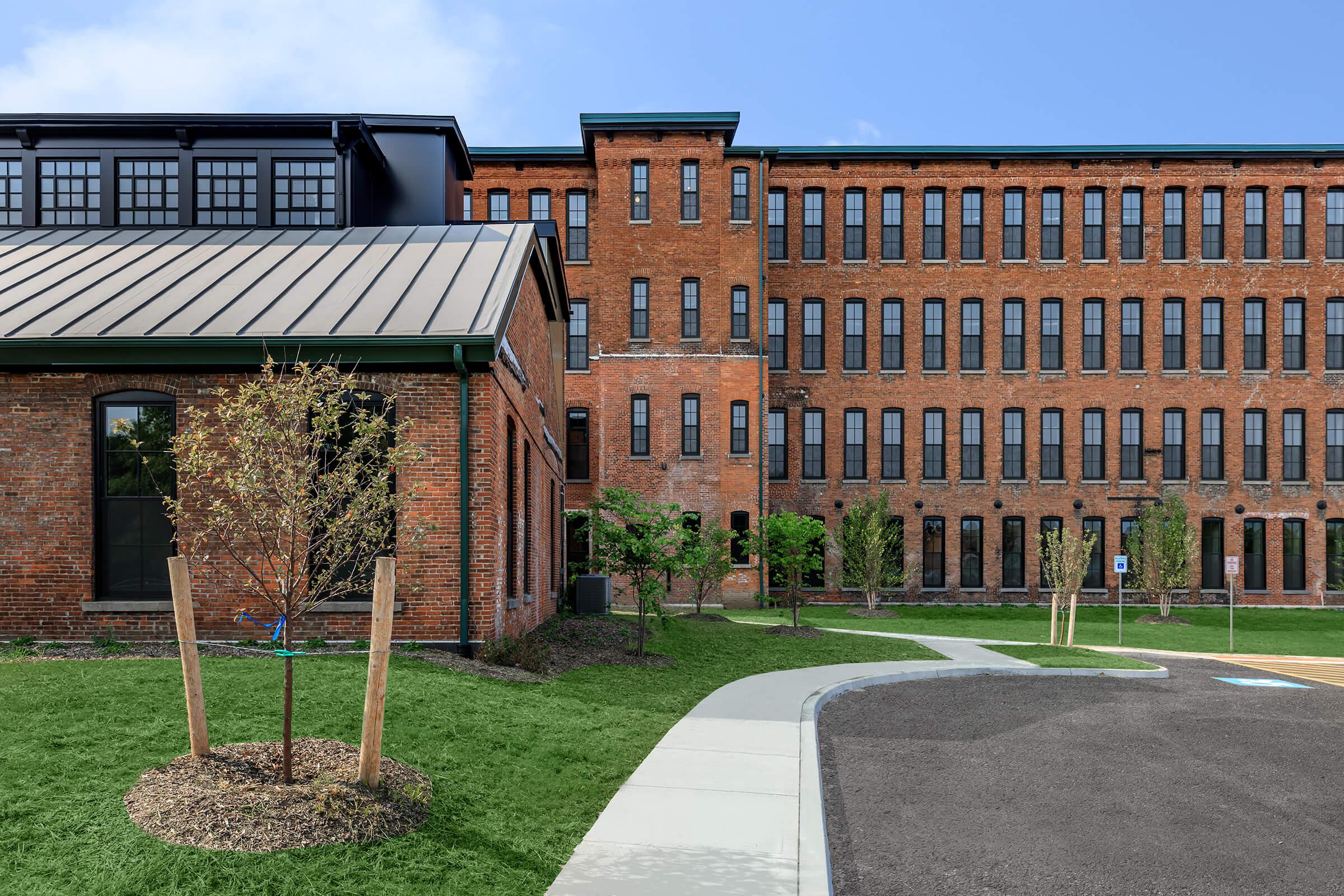 a large brick building with grass and trees