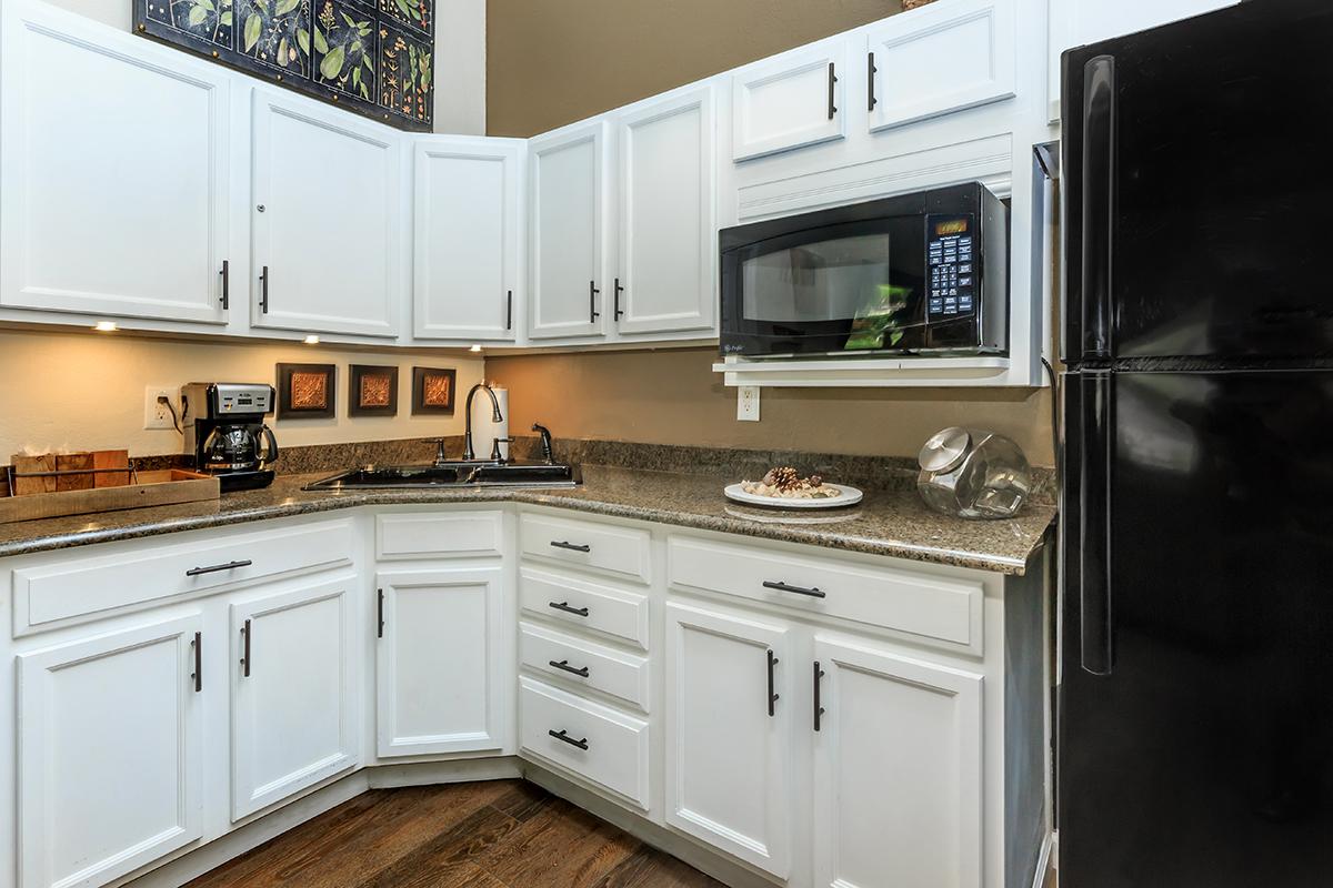 a kitchen with white cabinets and a microwave