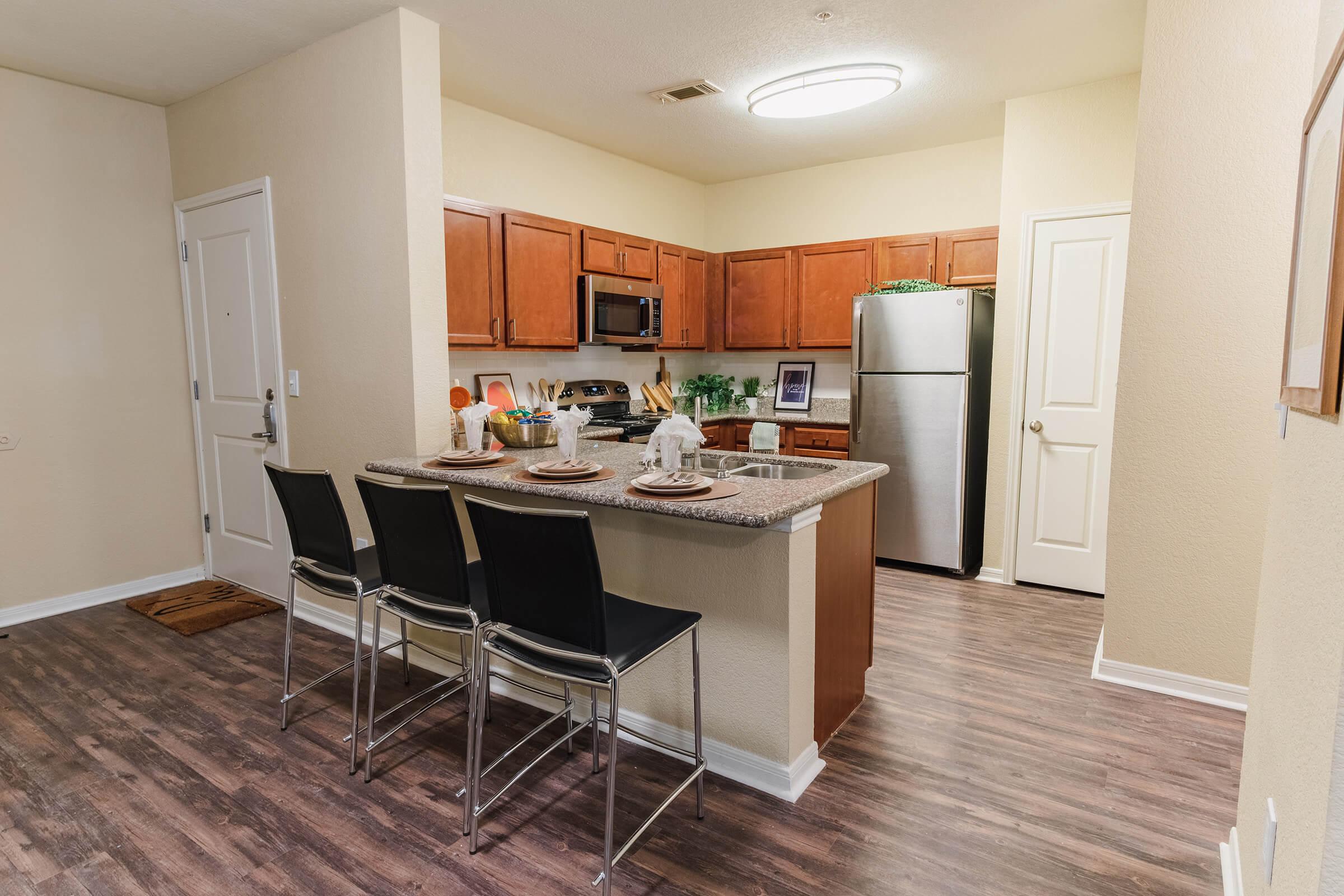 a kitchen with a stove refrigerator and table in a room