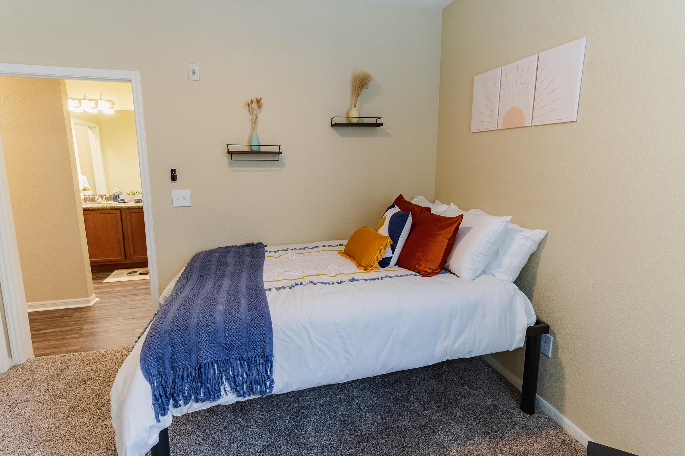 a bedroom with a bed and desk in a room