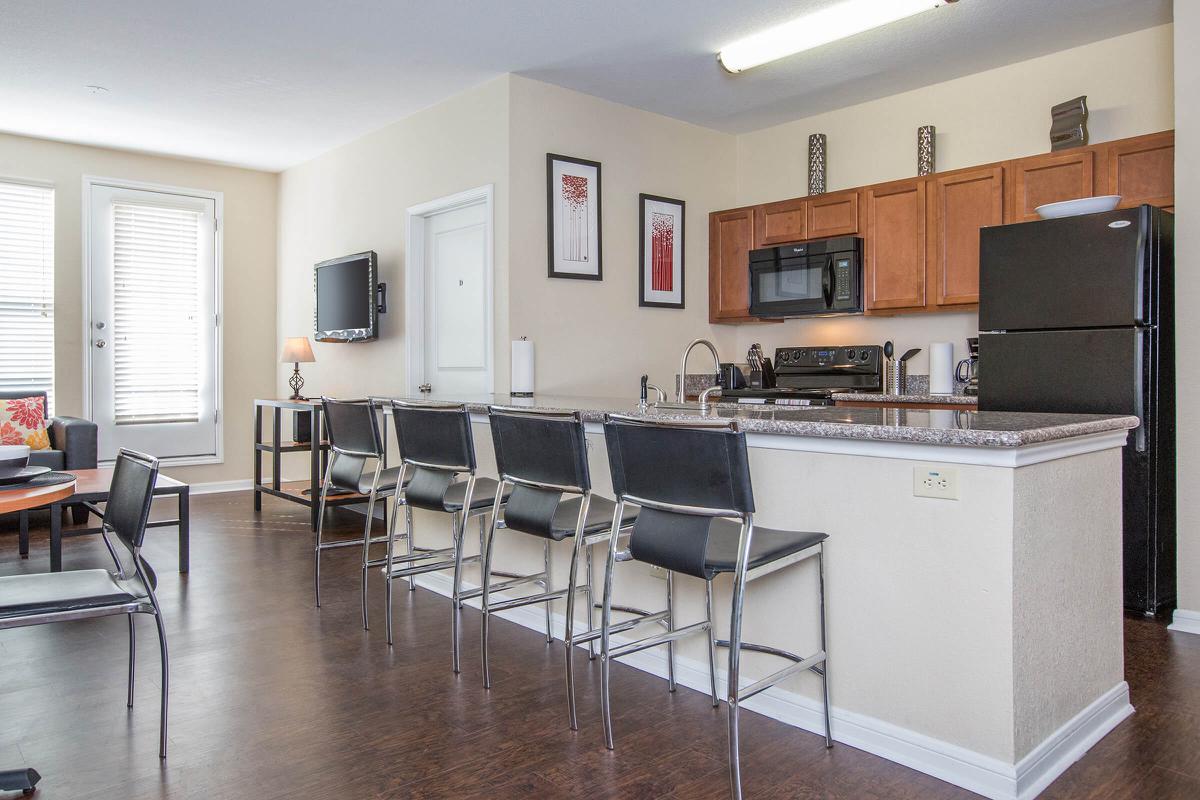 a living room filled with furniture and a table in a kitchen